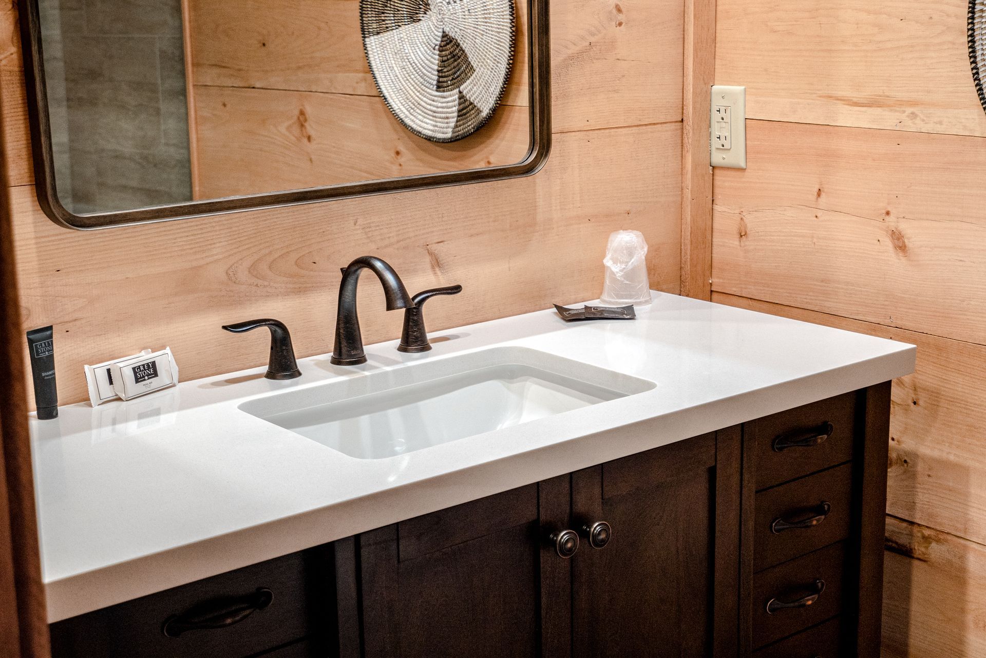 A bathroom with a sink , mirror and cabinets.