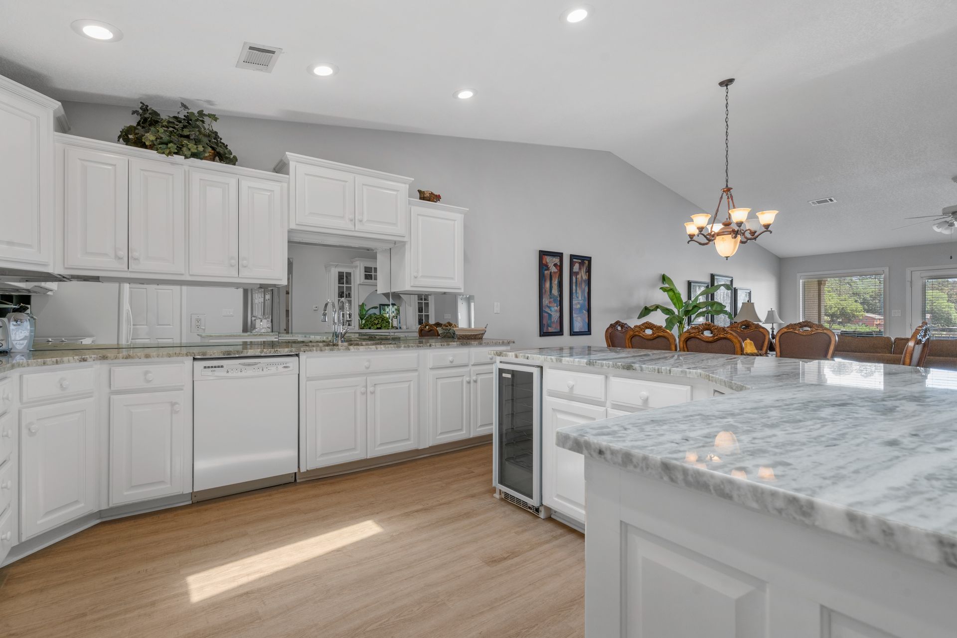 A kitchen with white cabinets and granite counter tops in a house.