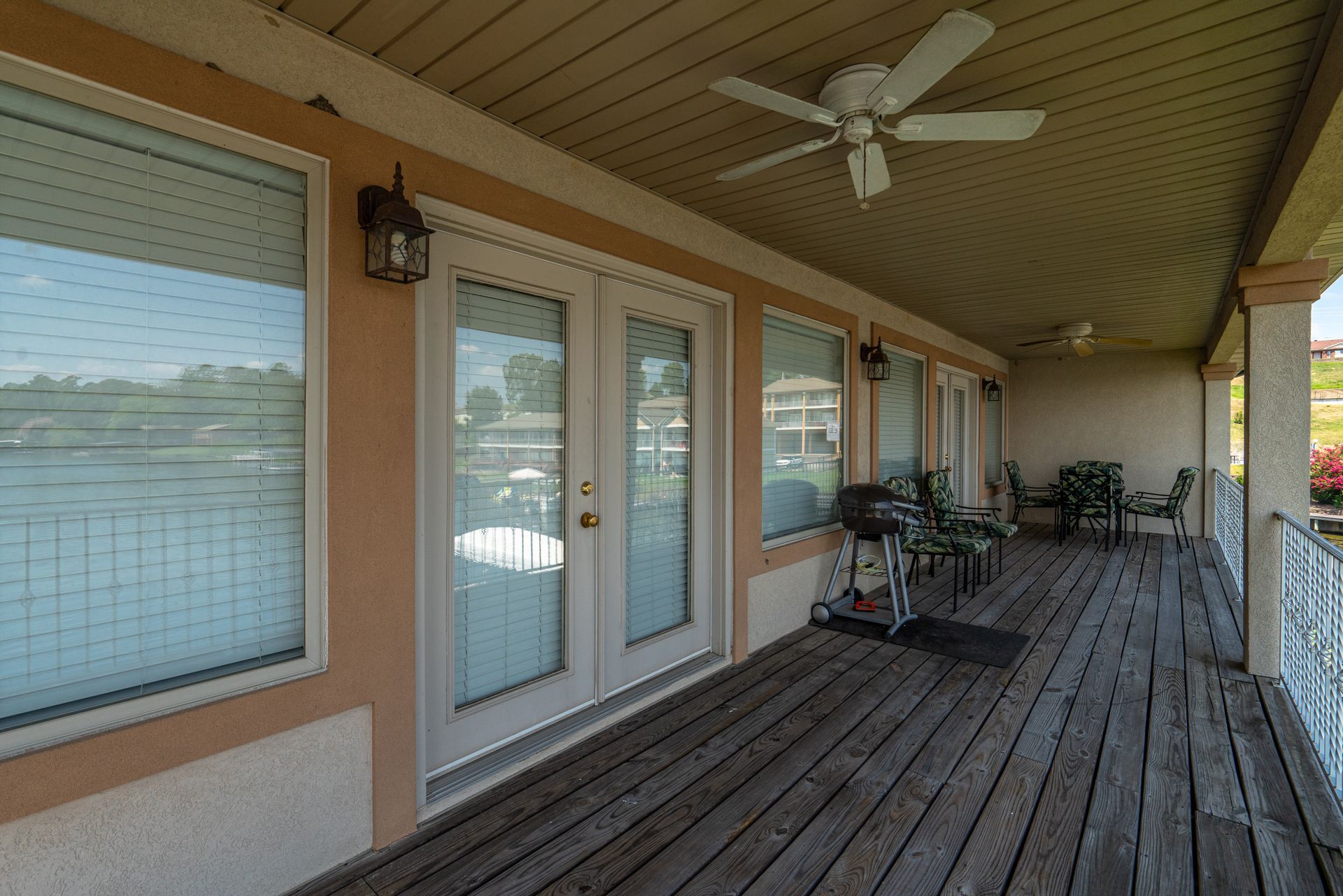 There is a ceiling fan on the porch of a house.