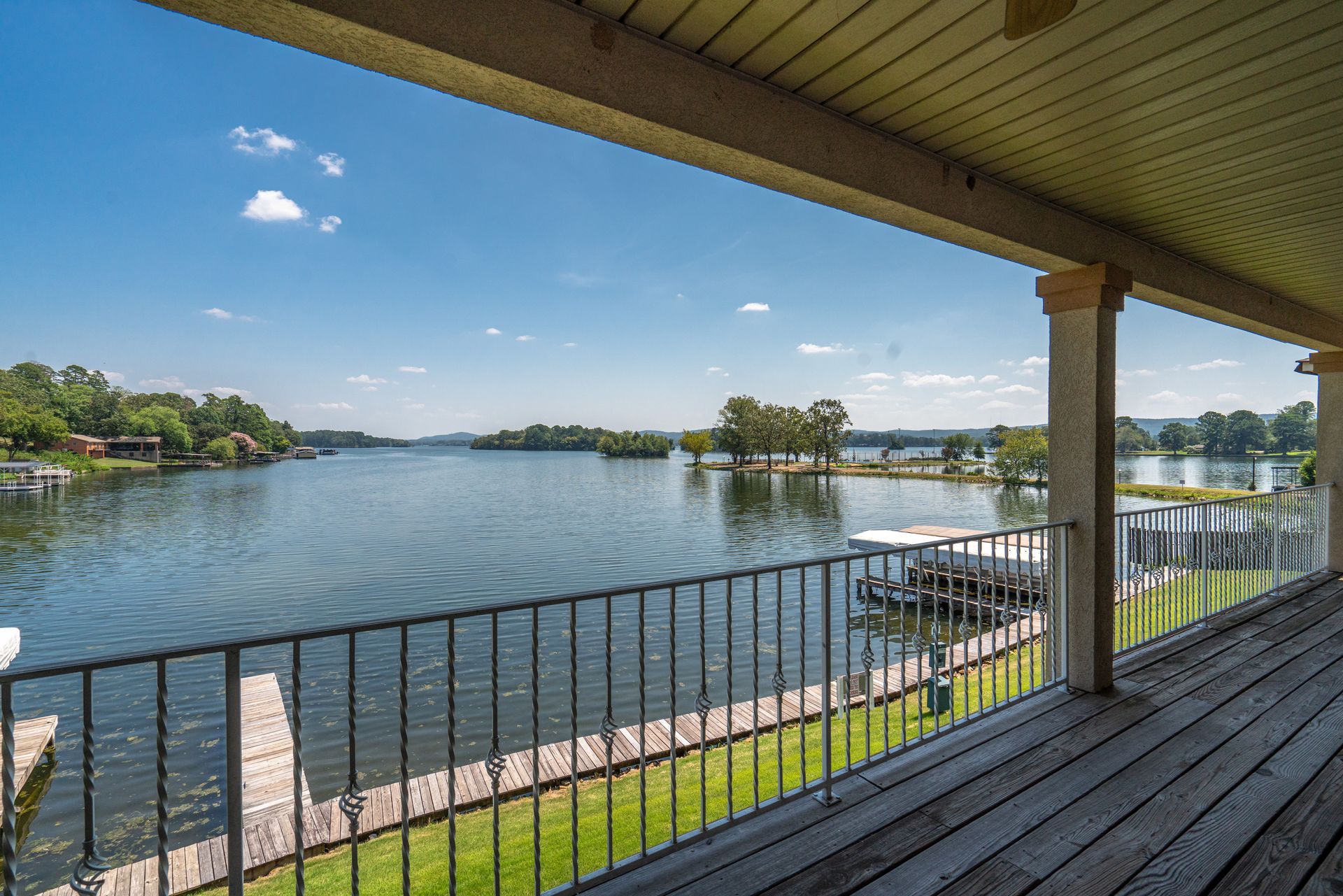 A view of a lake from a deck with a railing.