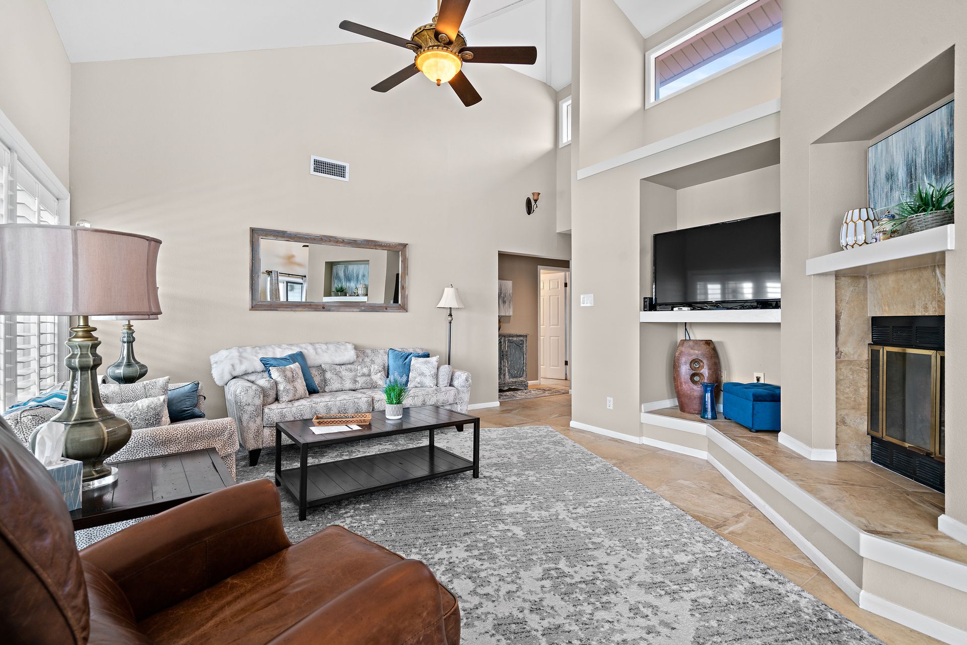 A living room with a ceiling fan and a fireplace
