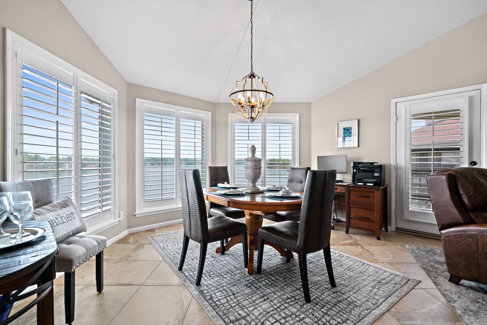 A dining room with a table and chairs and a chandelier.
