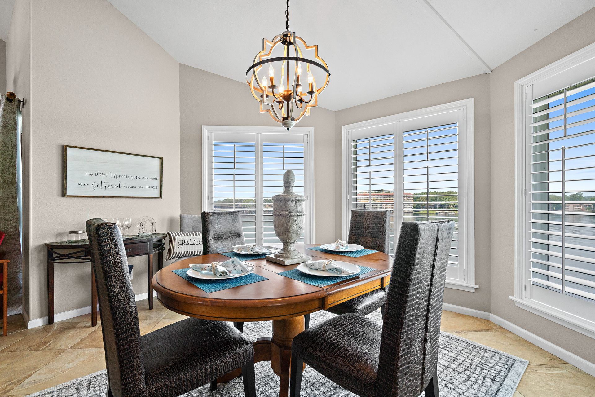 A dining room with a table and chairs and a chandelier.