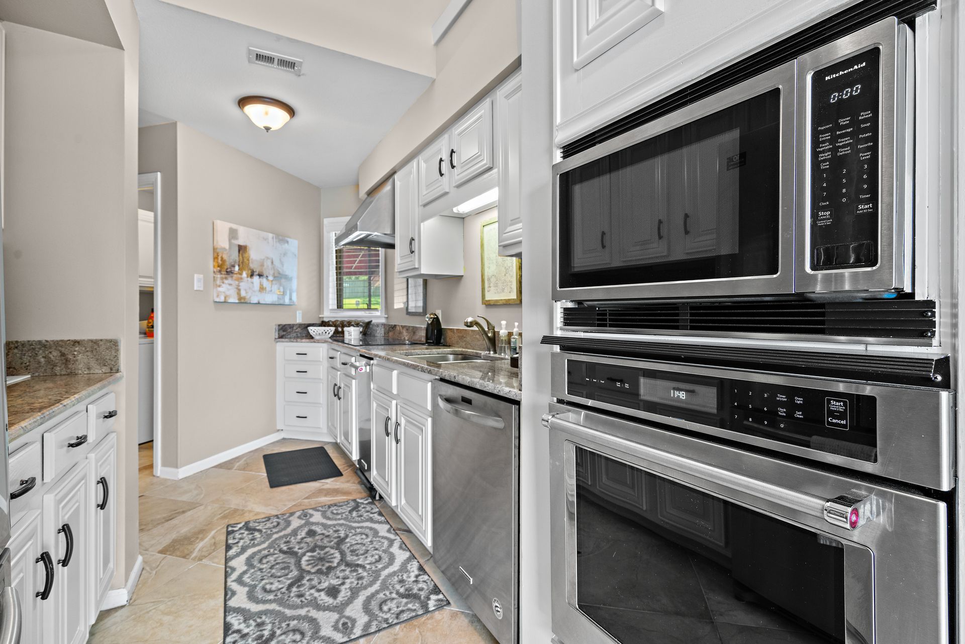 A kitchen with stainless steel appliances and white cabinets.