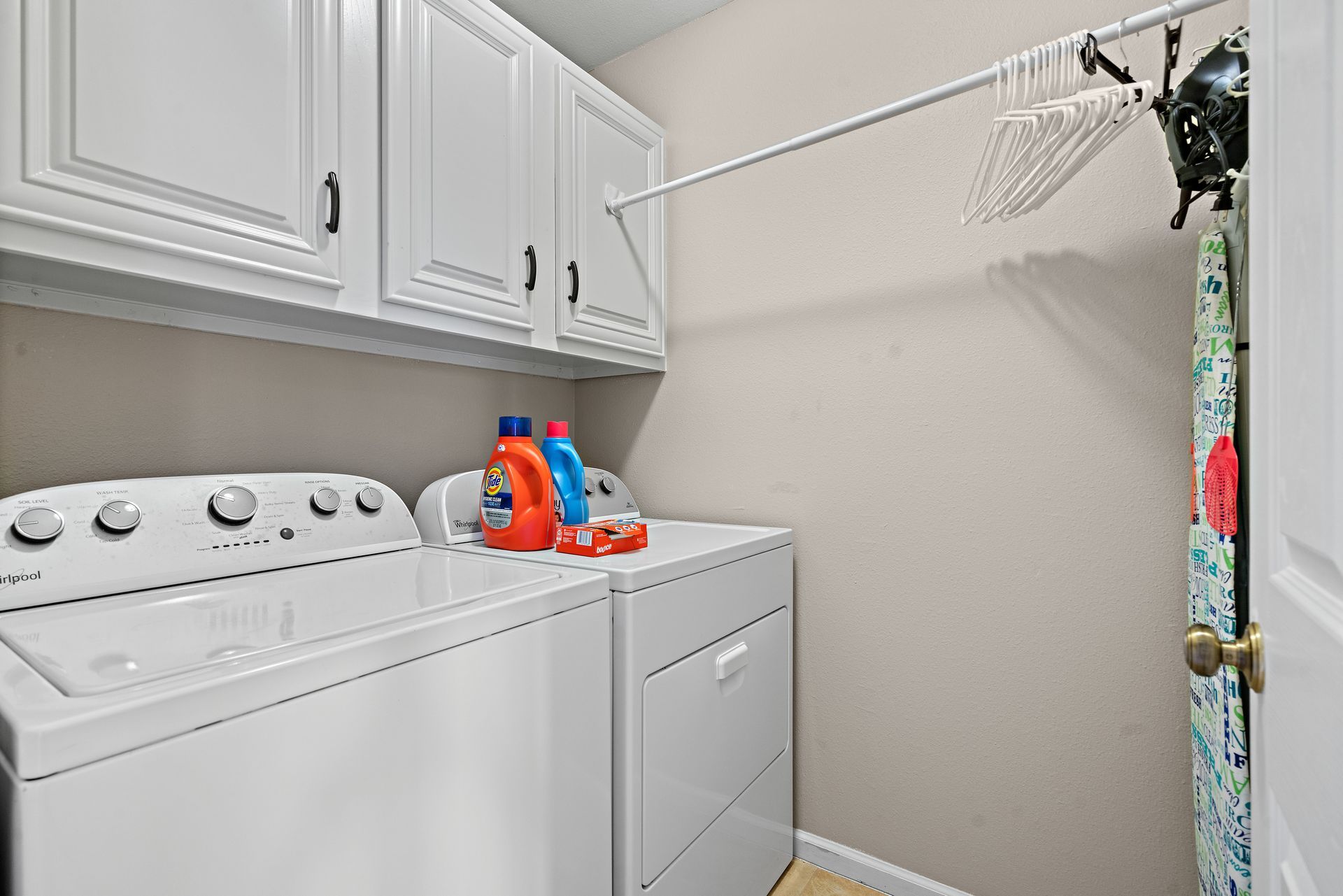 A laundry room with a washer and dryer and a clothesline.