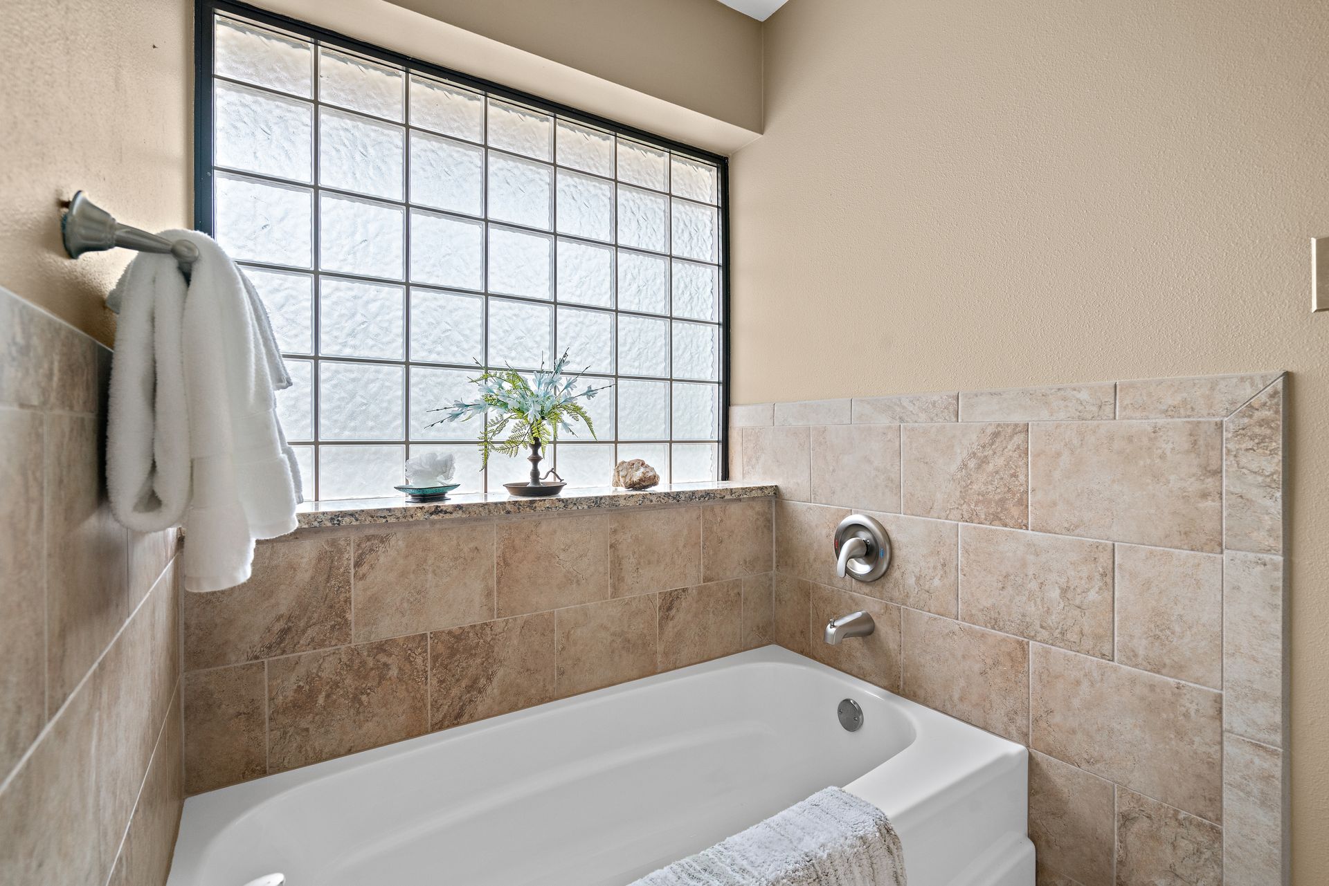 A bathroom with a bathtub and a window.