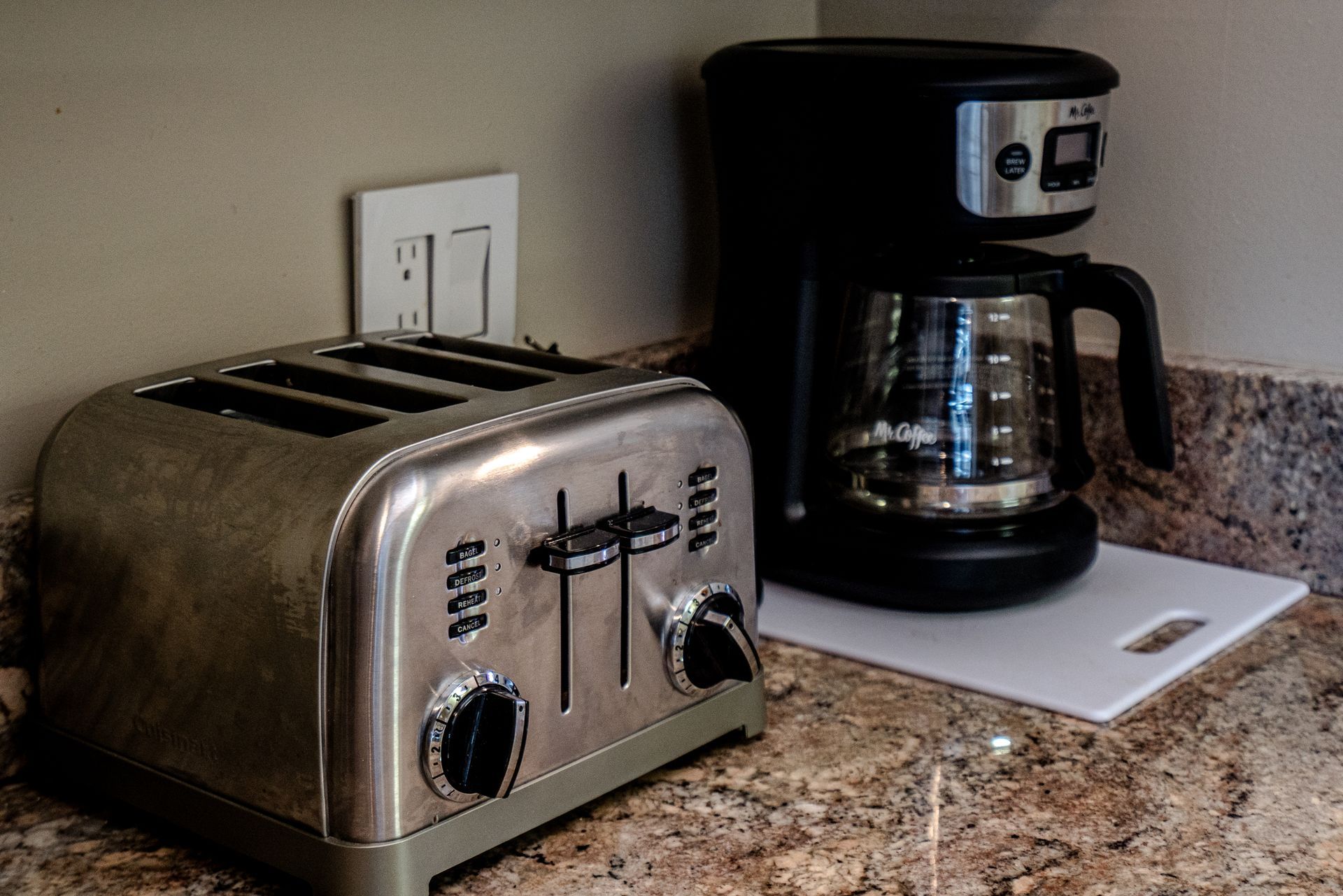 A toaster and a coffee maker are on a counter.