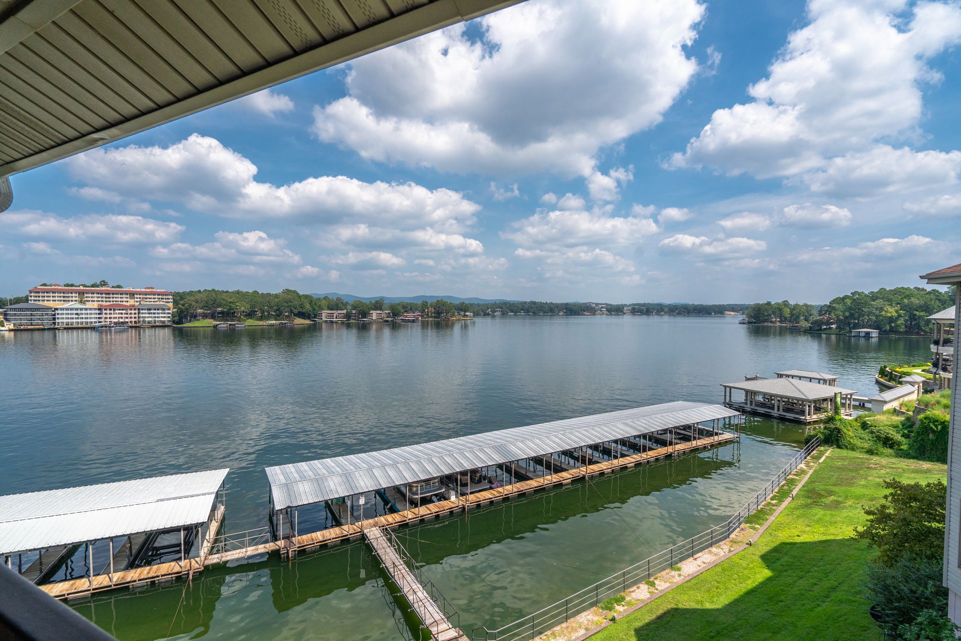 A view of a lake from a balcony with docked boats.