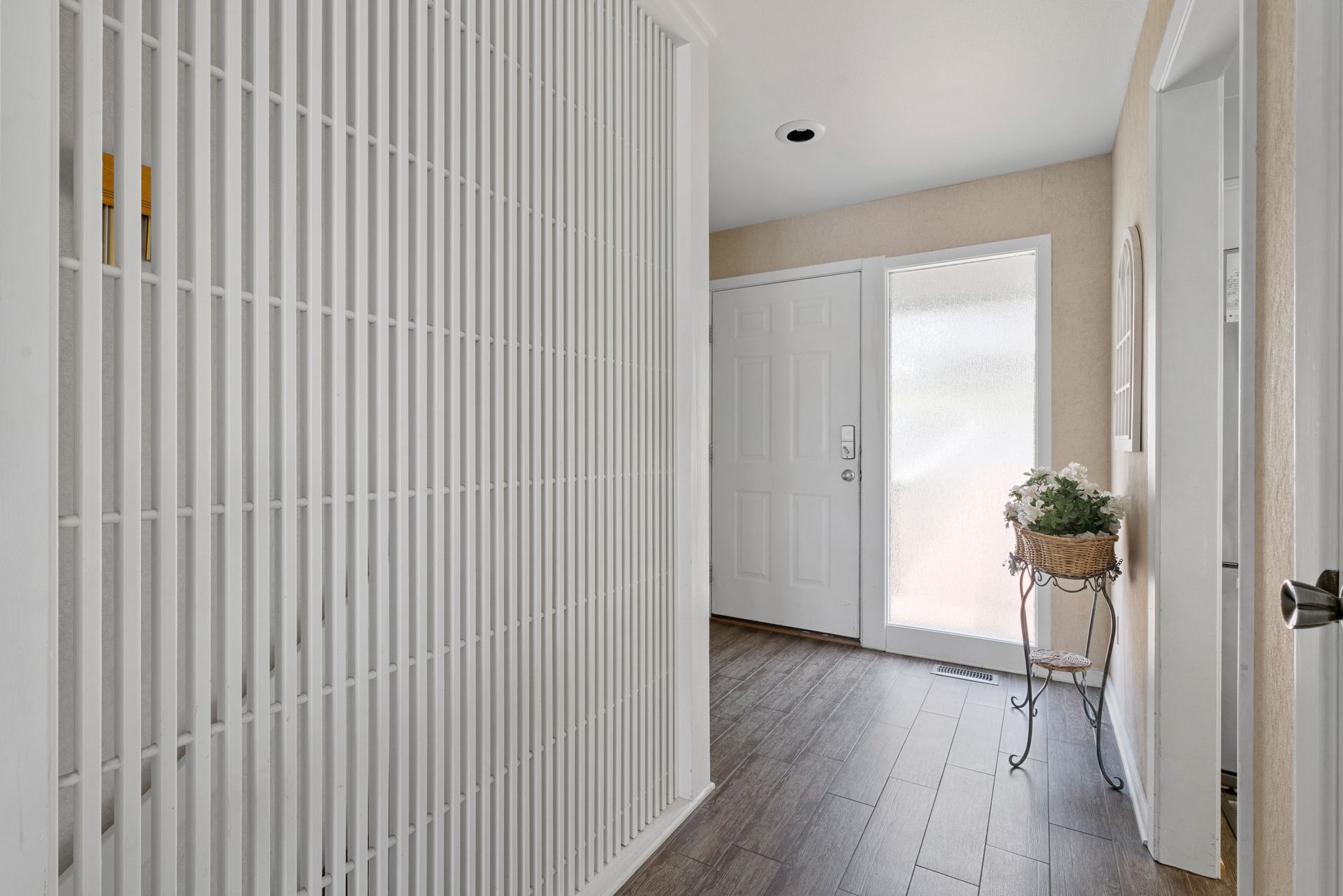 A hallway with a sliding glass door and a white wall.