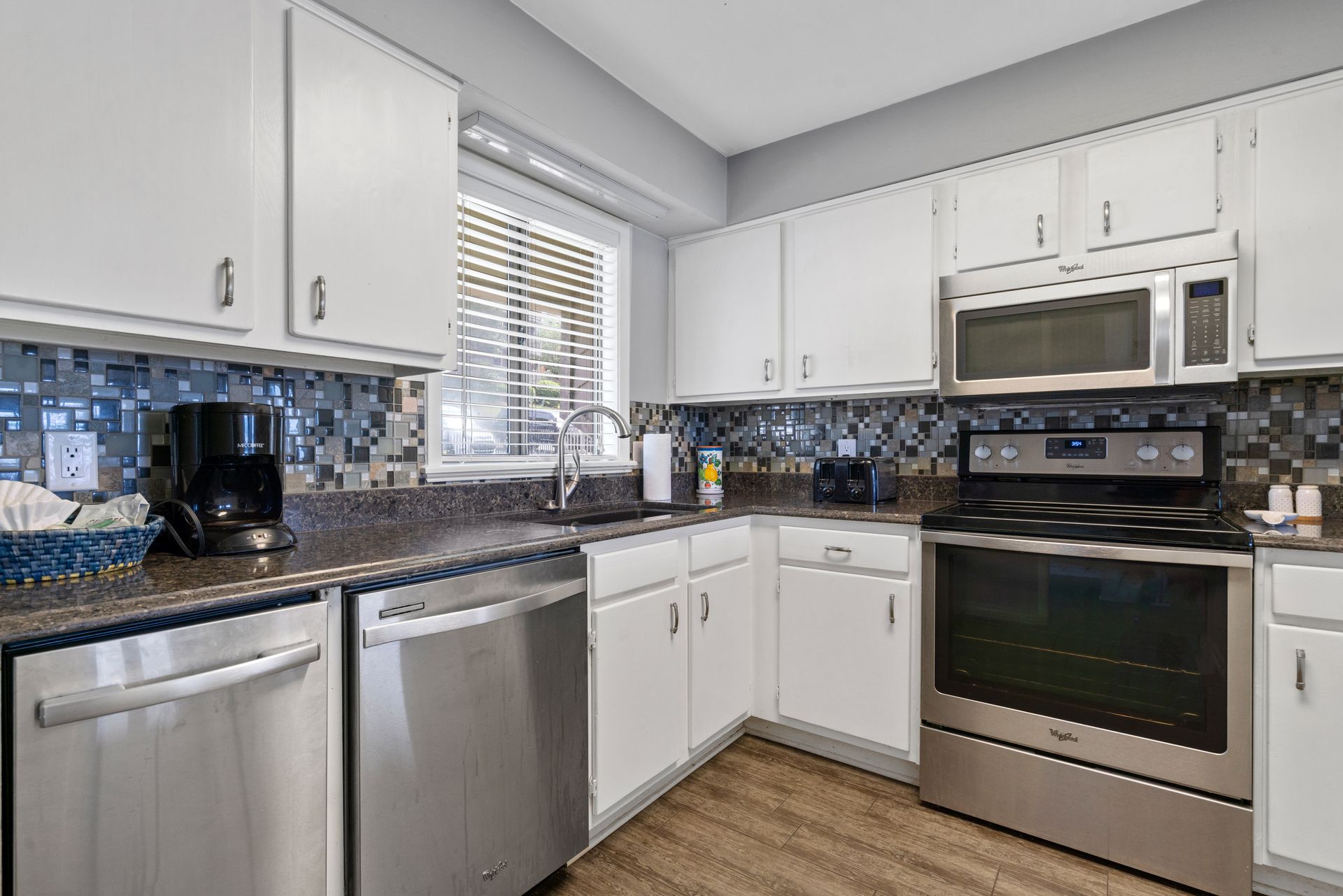 A kitchen with stainless steel appliances and white cabinets.