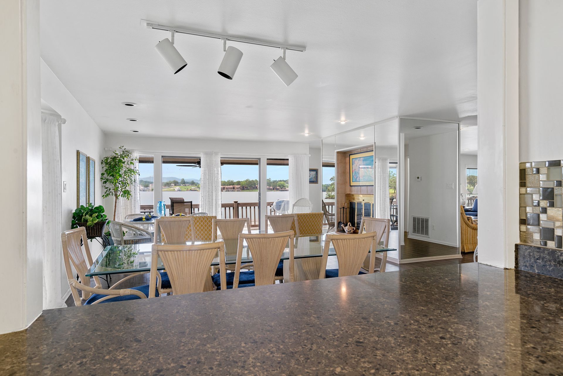 A kitchen counter with a view of a living room and dining room.