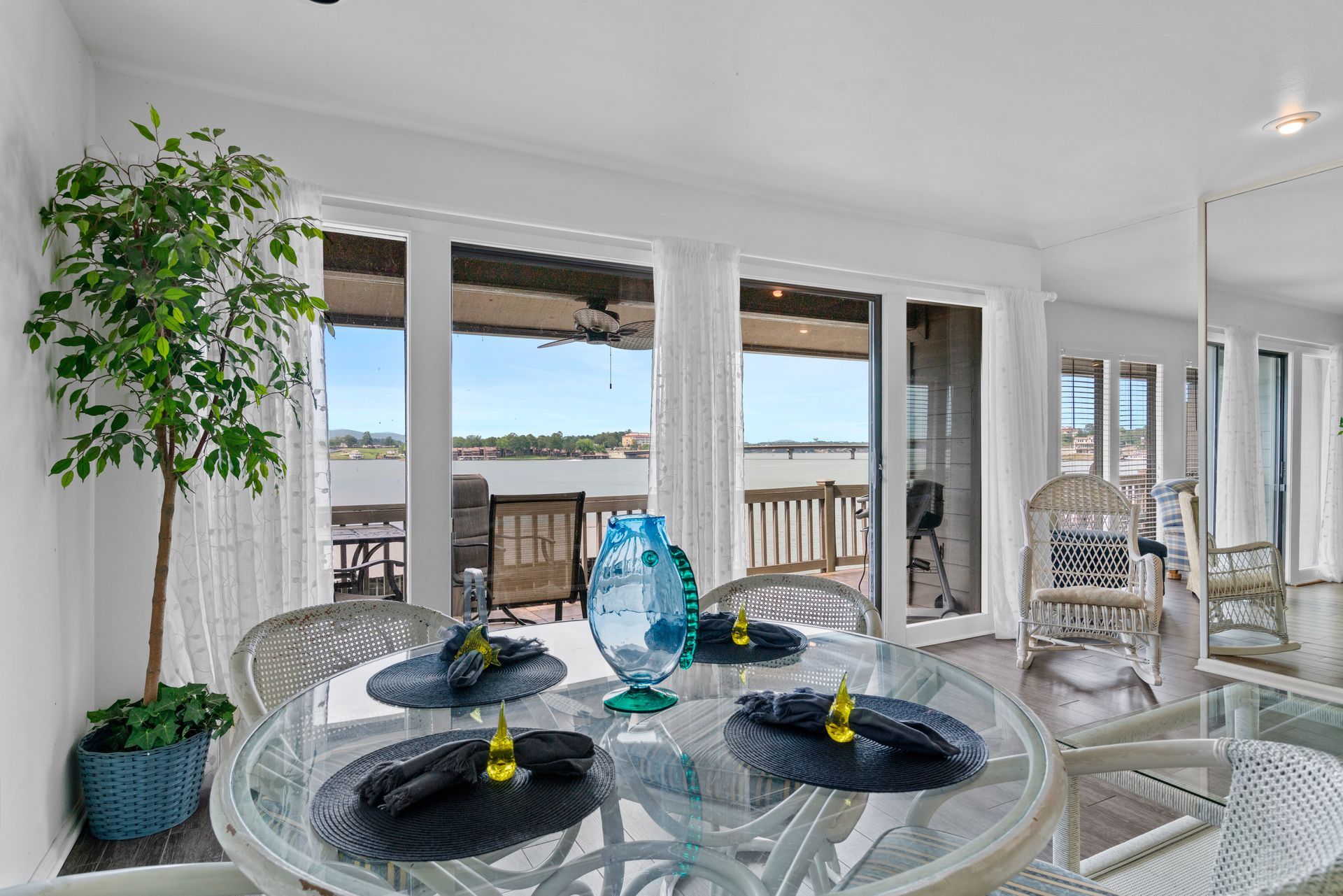 A dining room with a table and chairs and a view of the ocean.