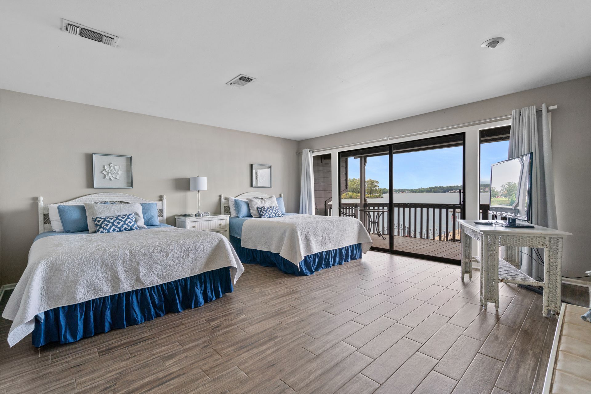A bedroom with two beds , a table and a balcony.