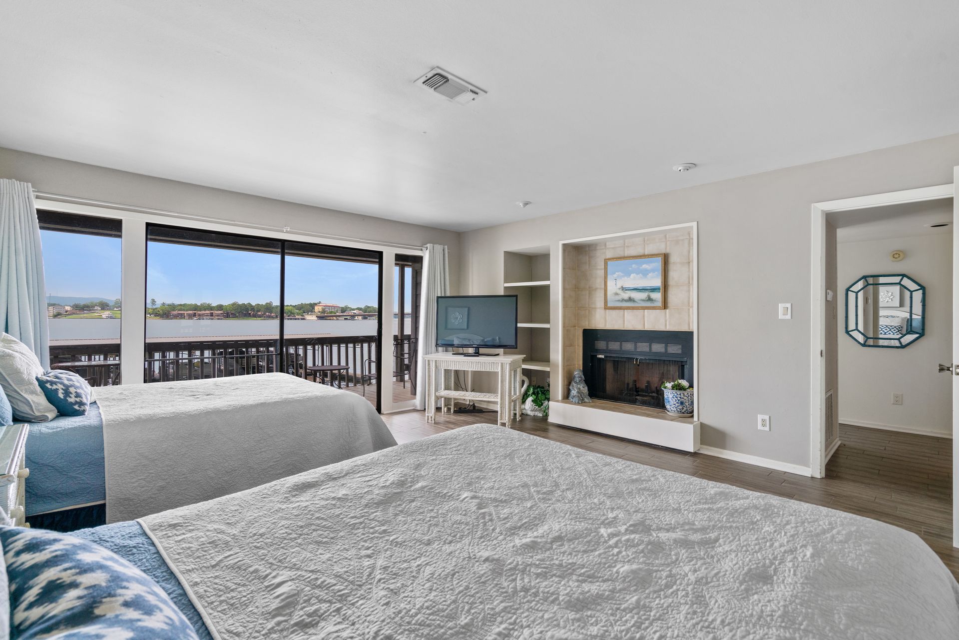 A bedroom with two beds , a fireplace and a television.