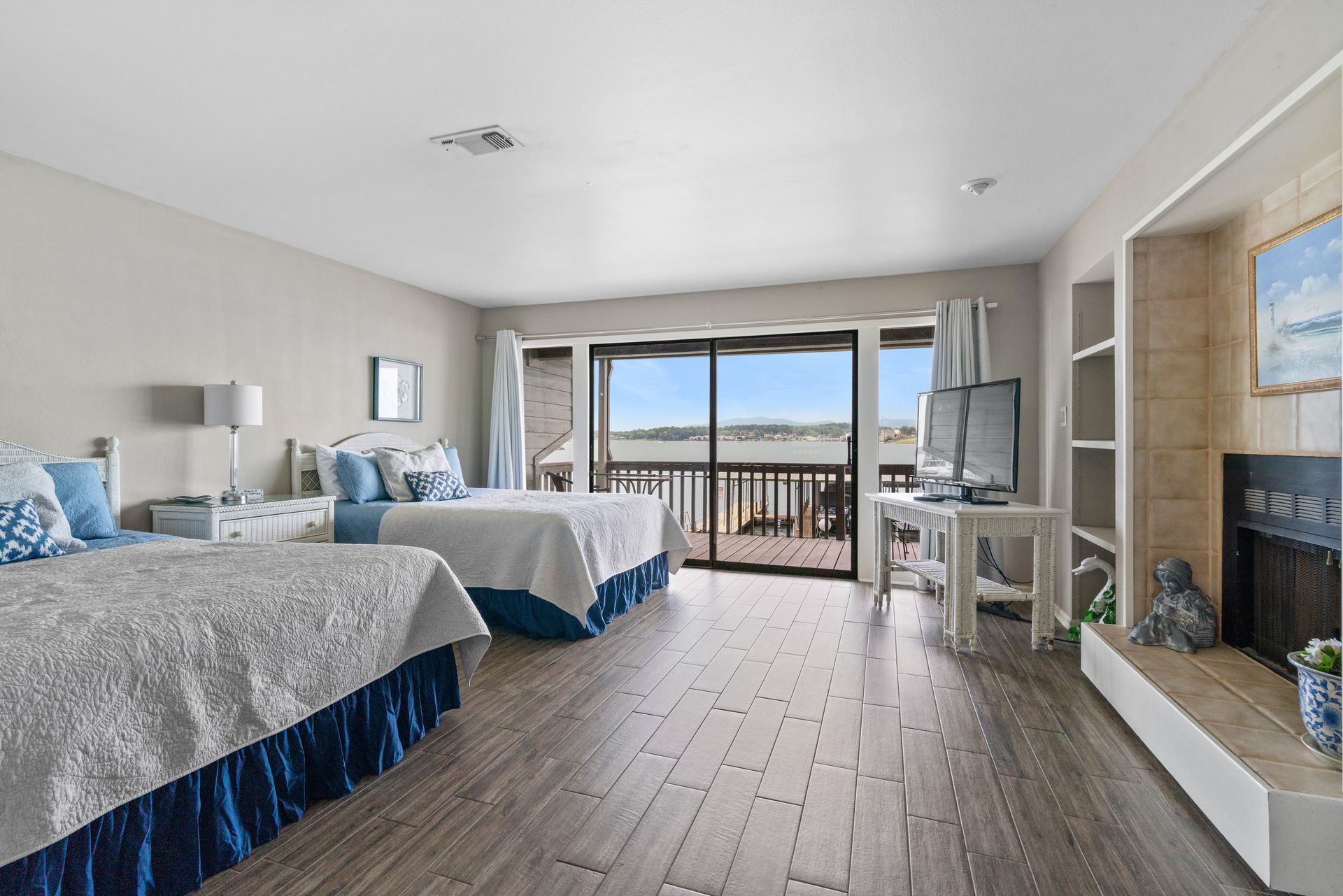A hotel room with two beds , a fireplace and a balcony.