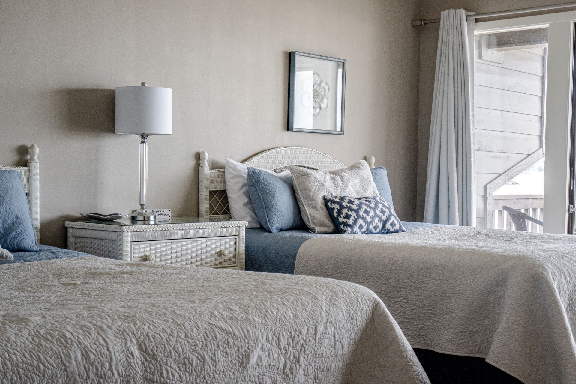 A bedroom with two beds and a lamp