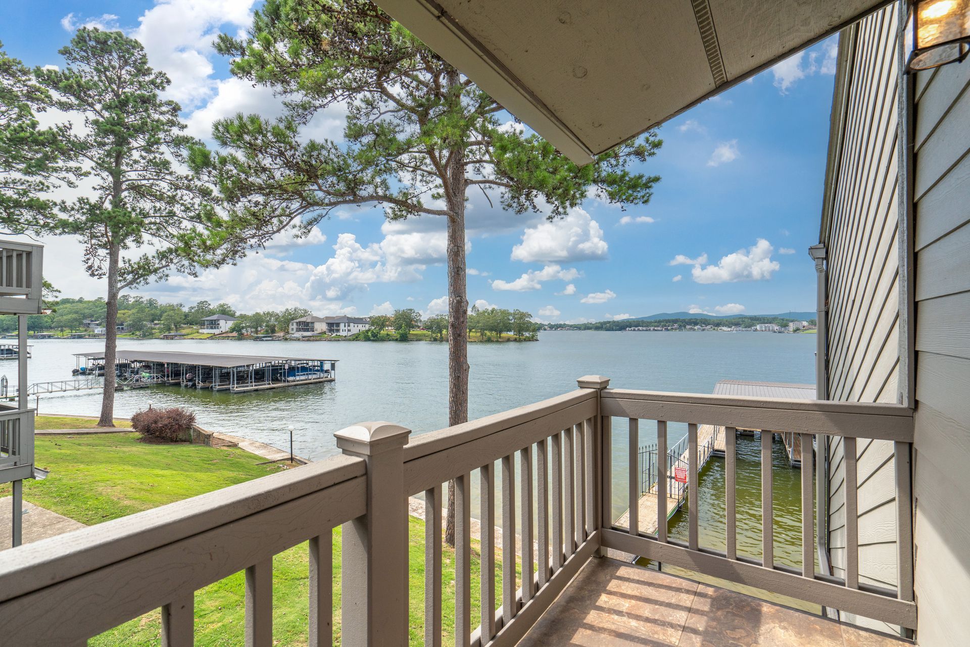 A balcony with a view of a lake and a dock.