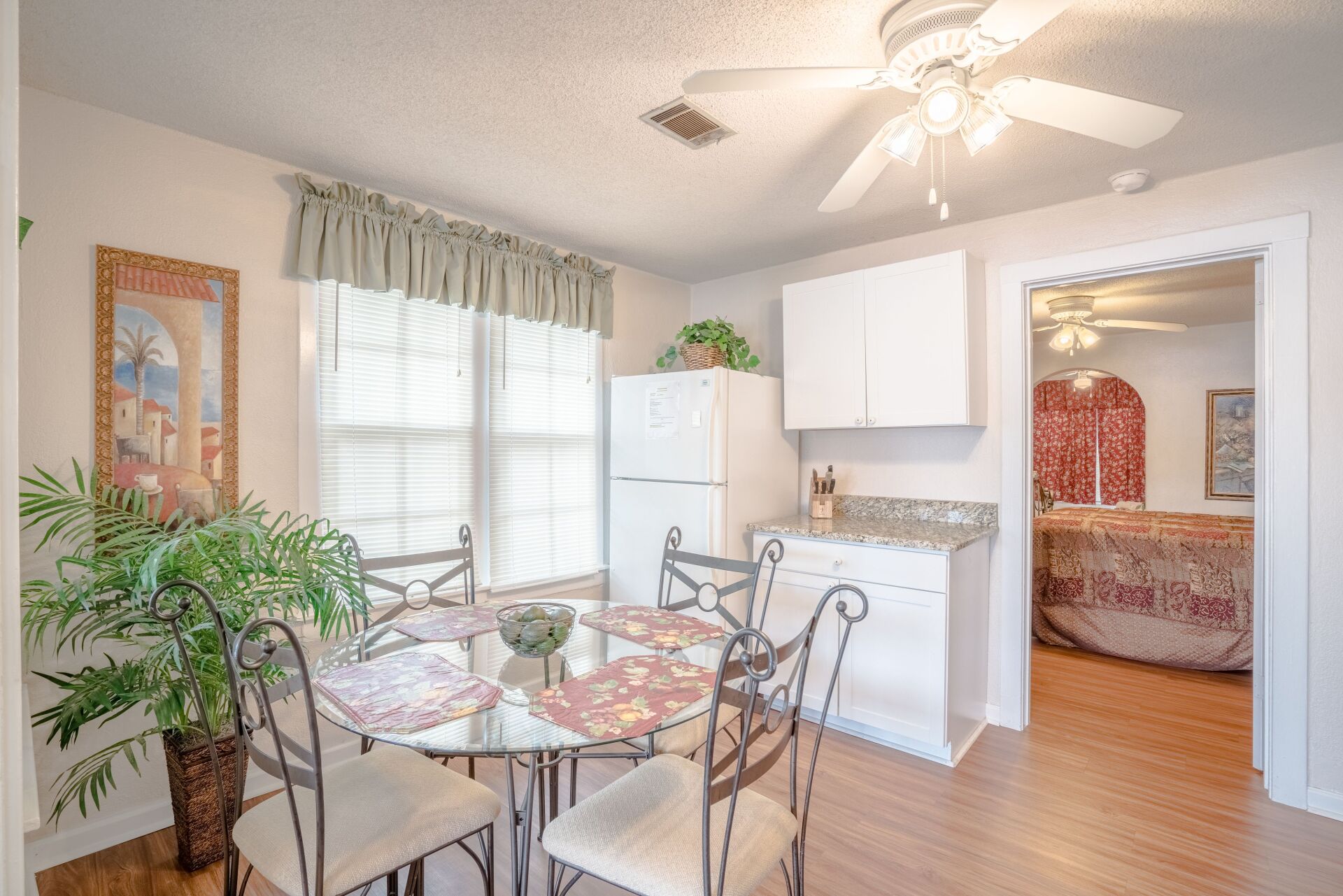 A dining room with a table and chairs and a ceiling fan.