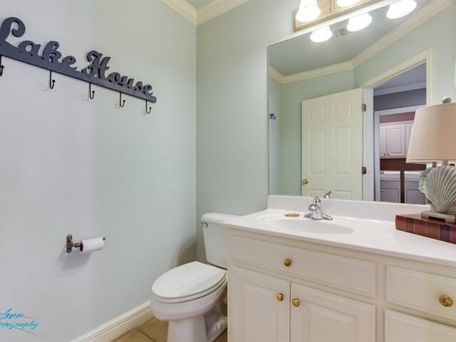 A bathroom with a toilet , sink and mirror.
