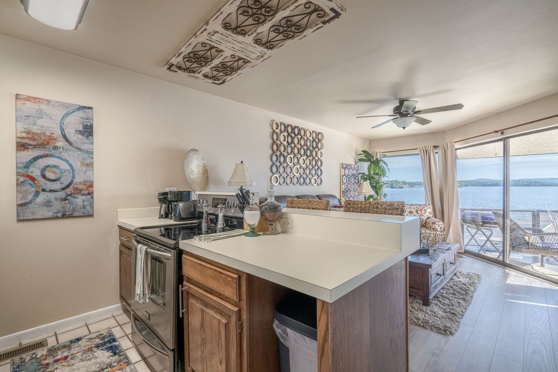 A kitchen with a large island , stainless steel appliances , and a ceiling fan.