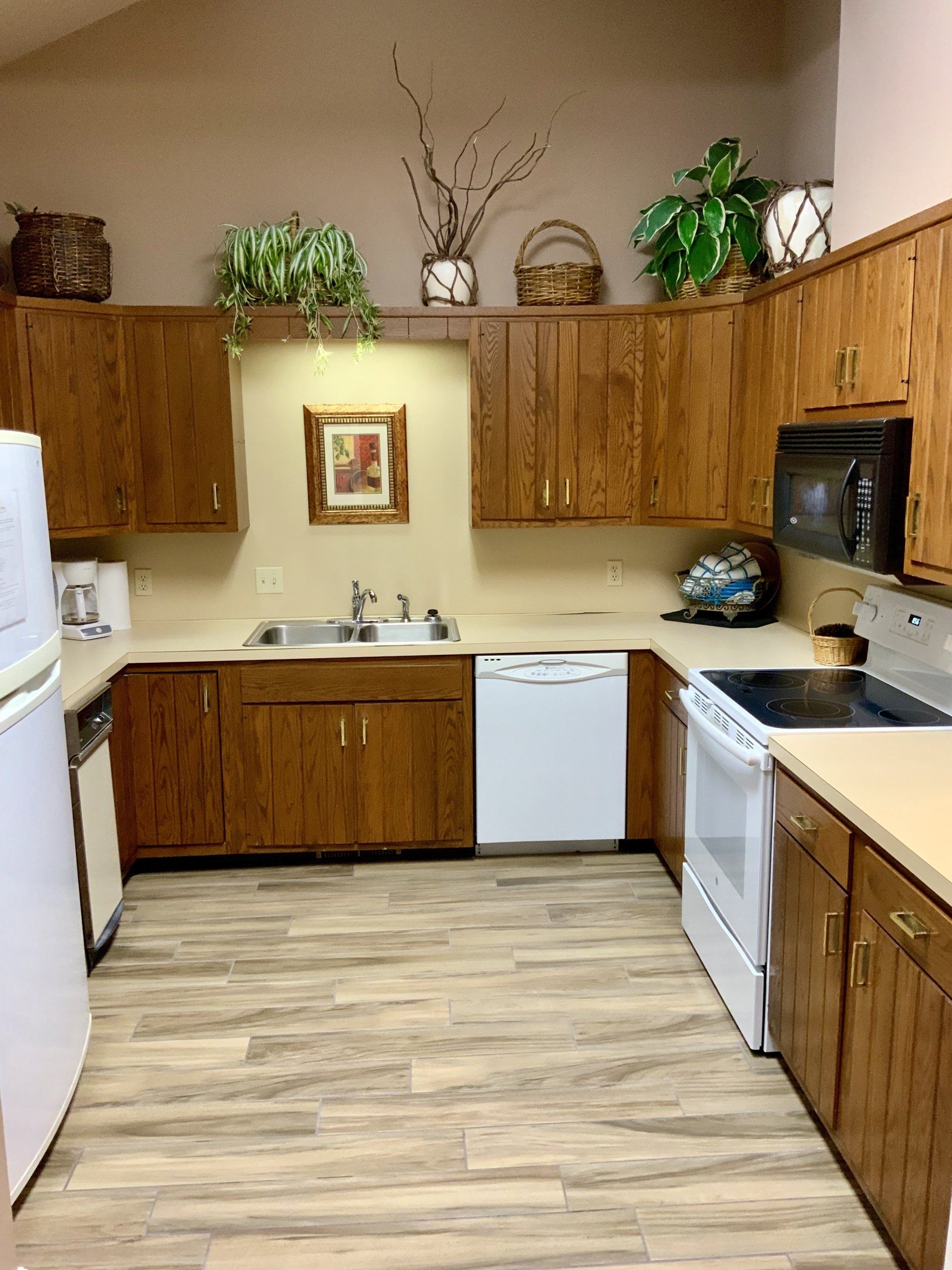 A kitchen with wooden cabinets and white appliances