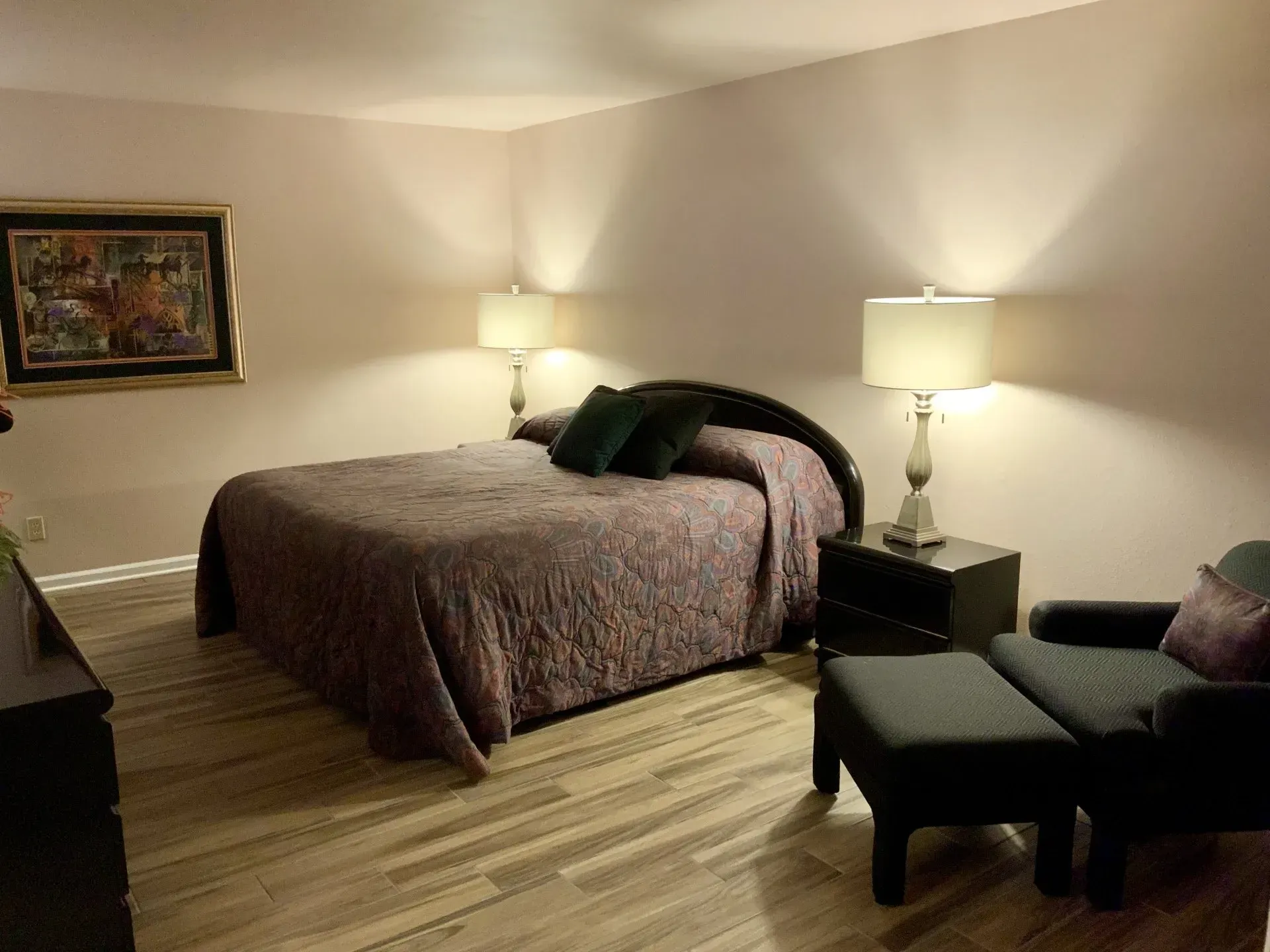 A bedroom with a king size bed and a chair