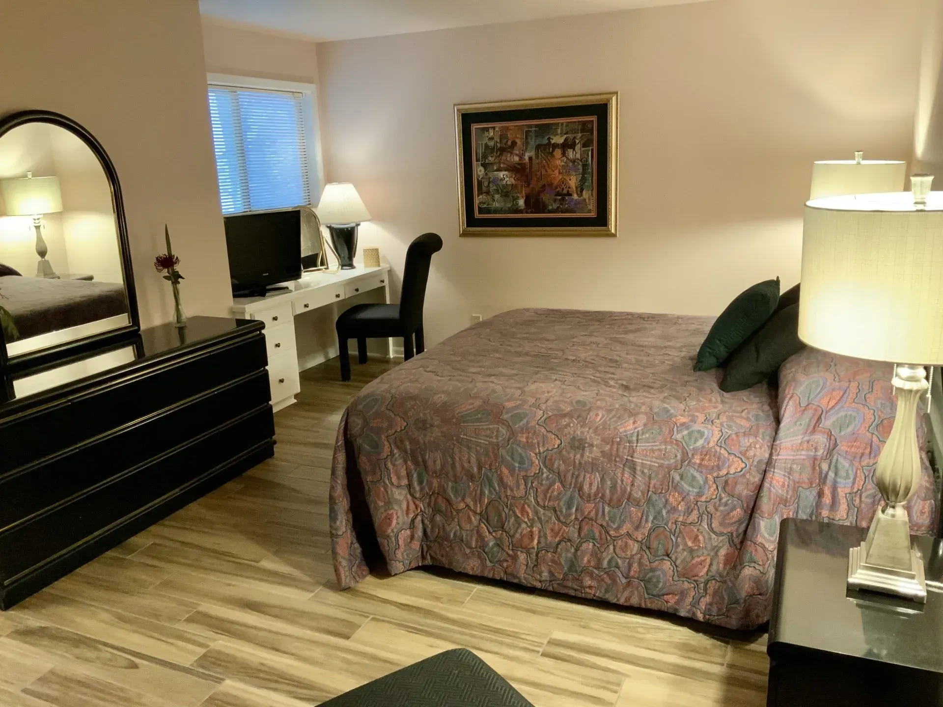 A bedroom with a king size bed and a dresser