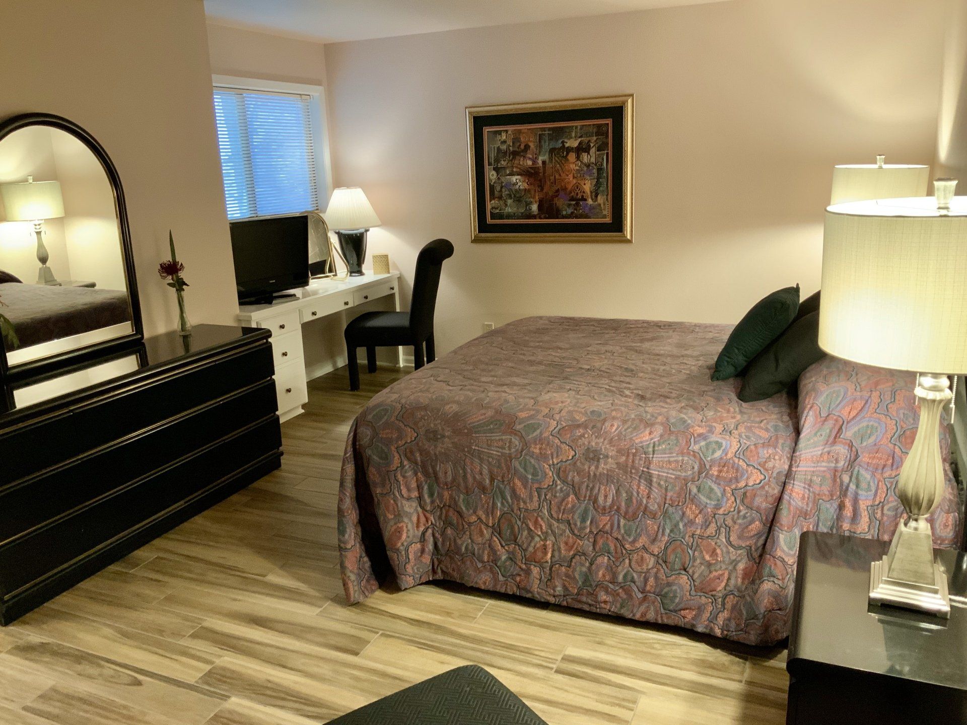 A bedroom with a large bed and a dresser