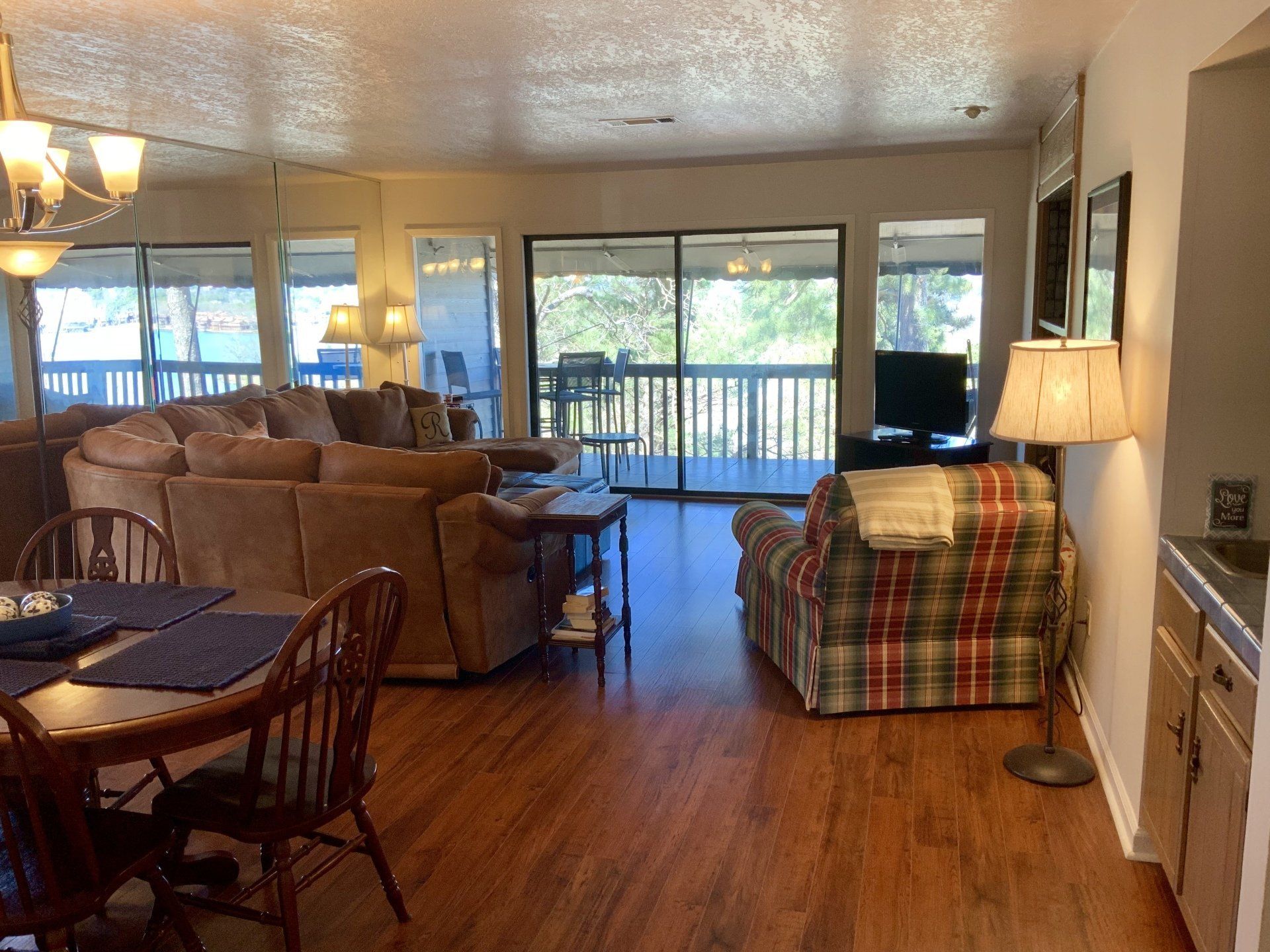 A living room with a couch , chair , table and sliding glass doors.