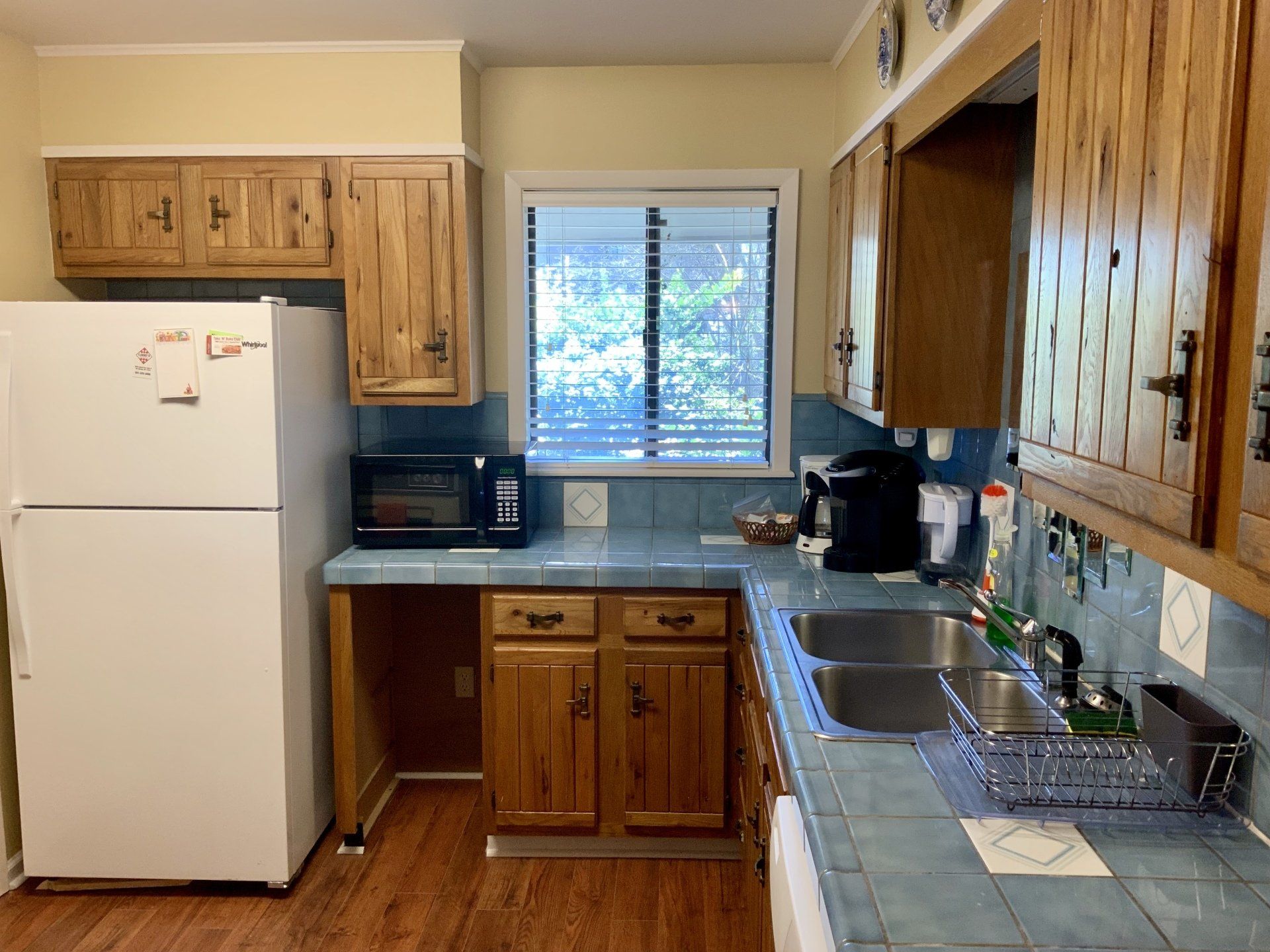 A kitchen with a white refrigerator and wooden cabinets