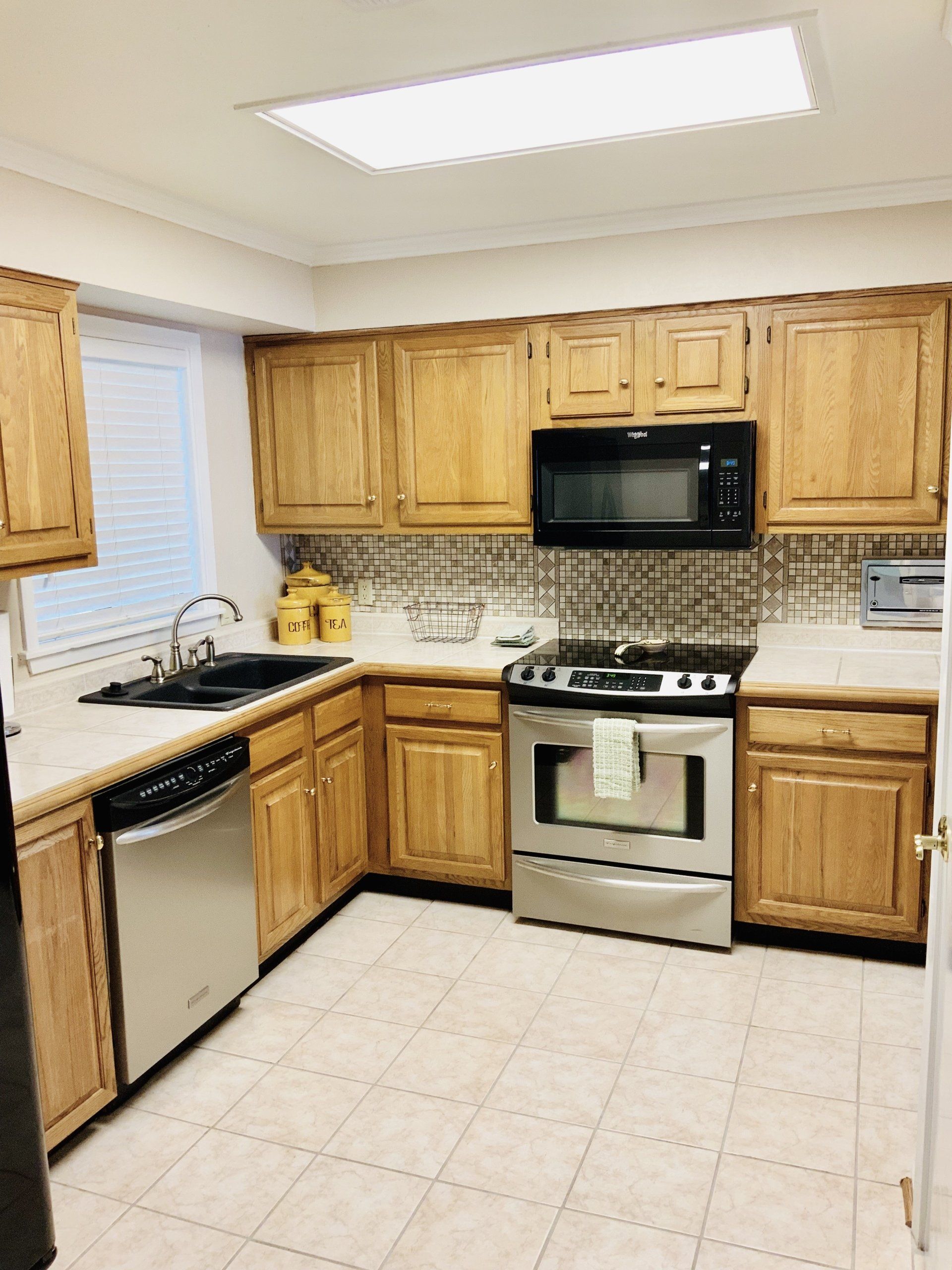 A kitchen with wooden cabinets and stainless steel appliances