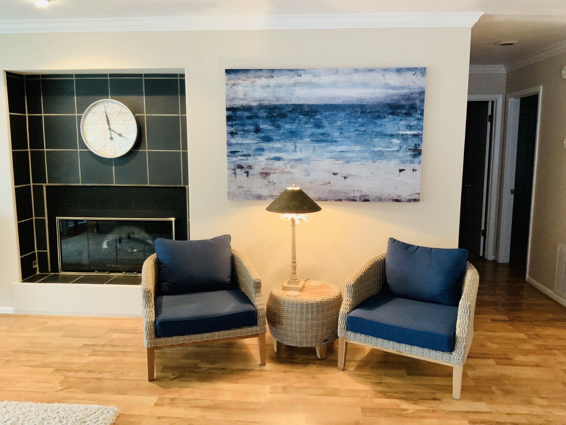 A living room with two chairs and a clock on the wall