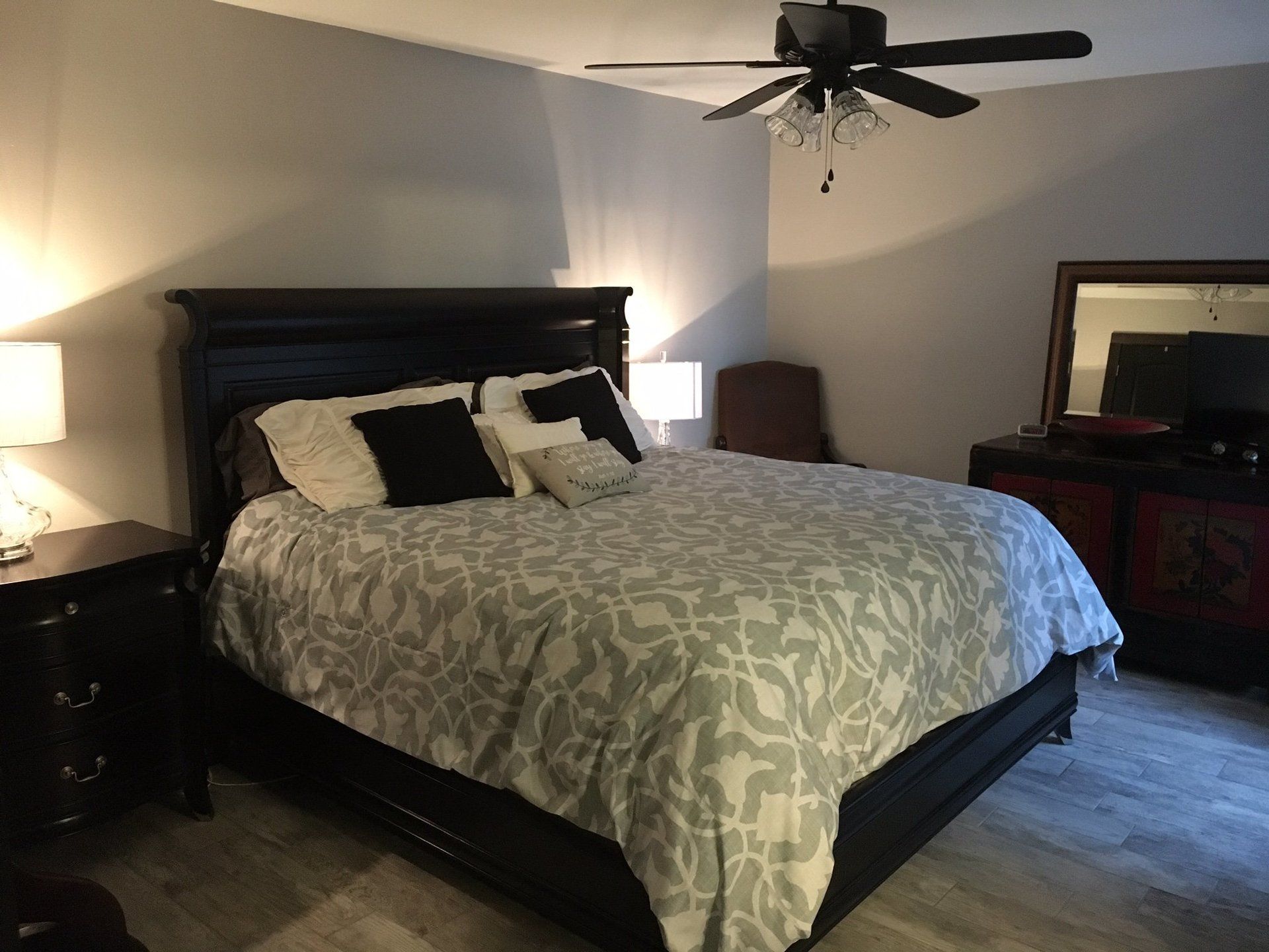 A bedroom with a bed and a ceiling fan