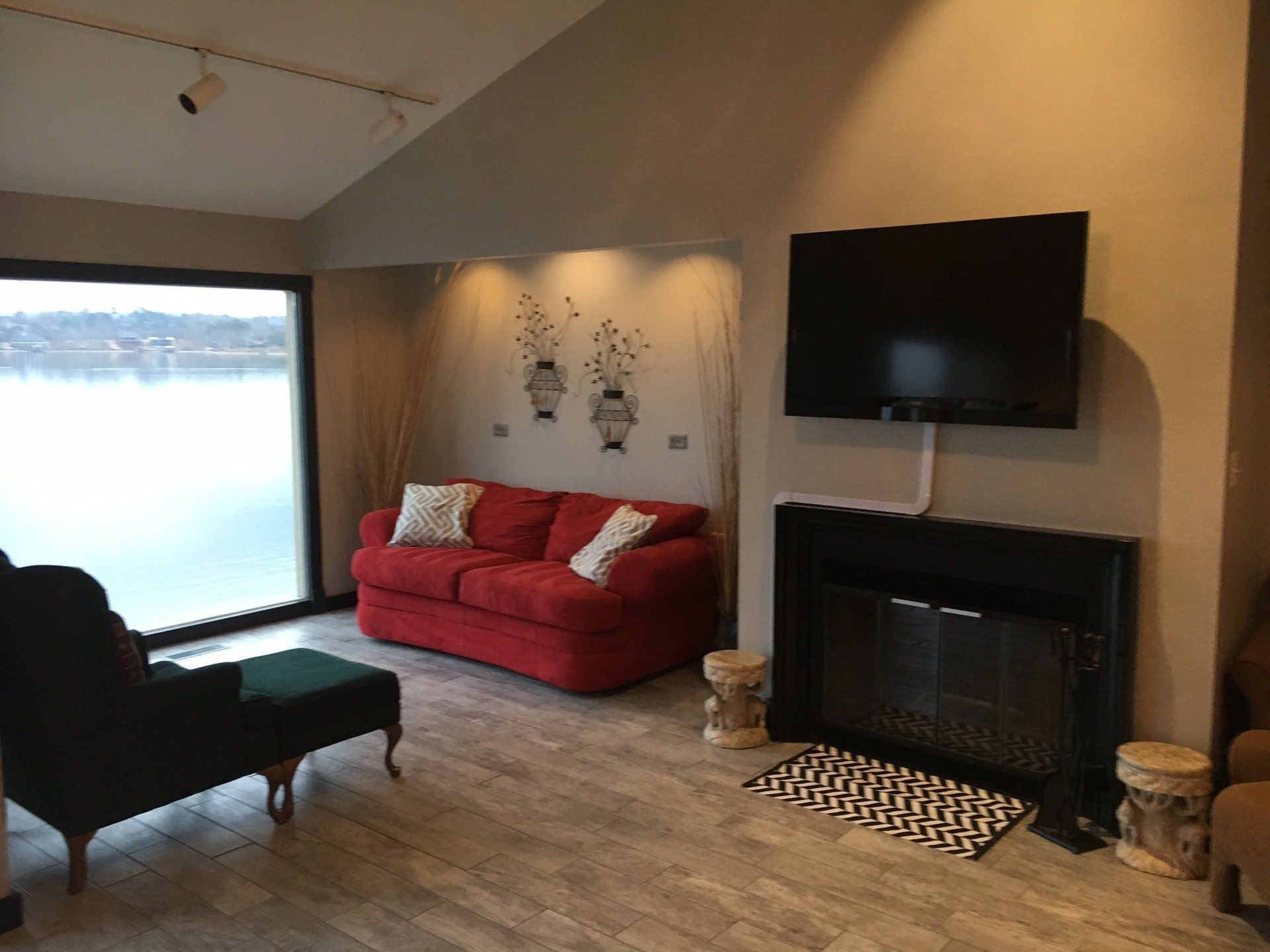 A living room with a red couch and a fireplace