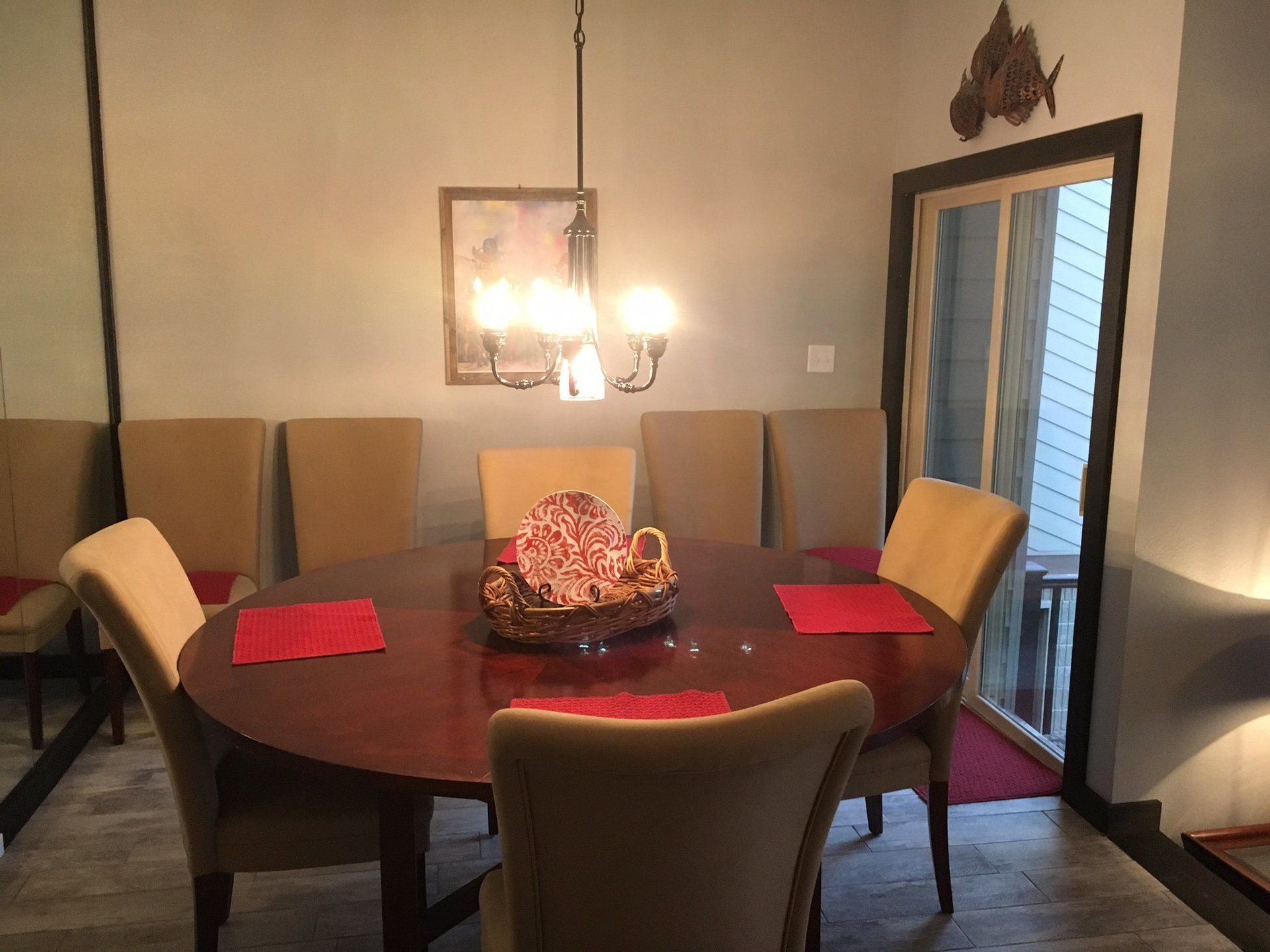 A dining room with a round table and chairs and a chandelier.