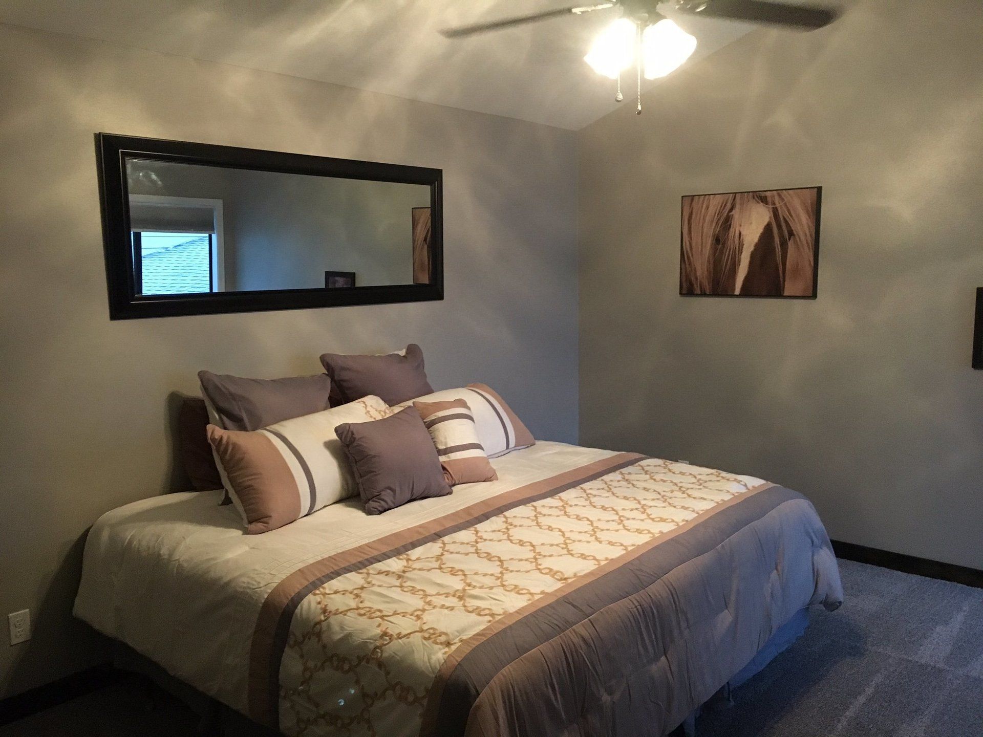 A bedroom with a large bed and a mirror