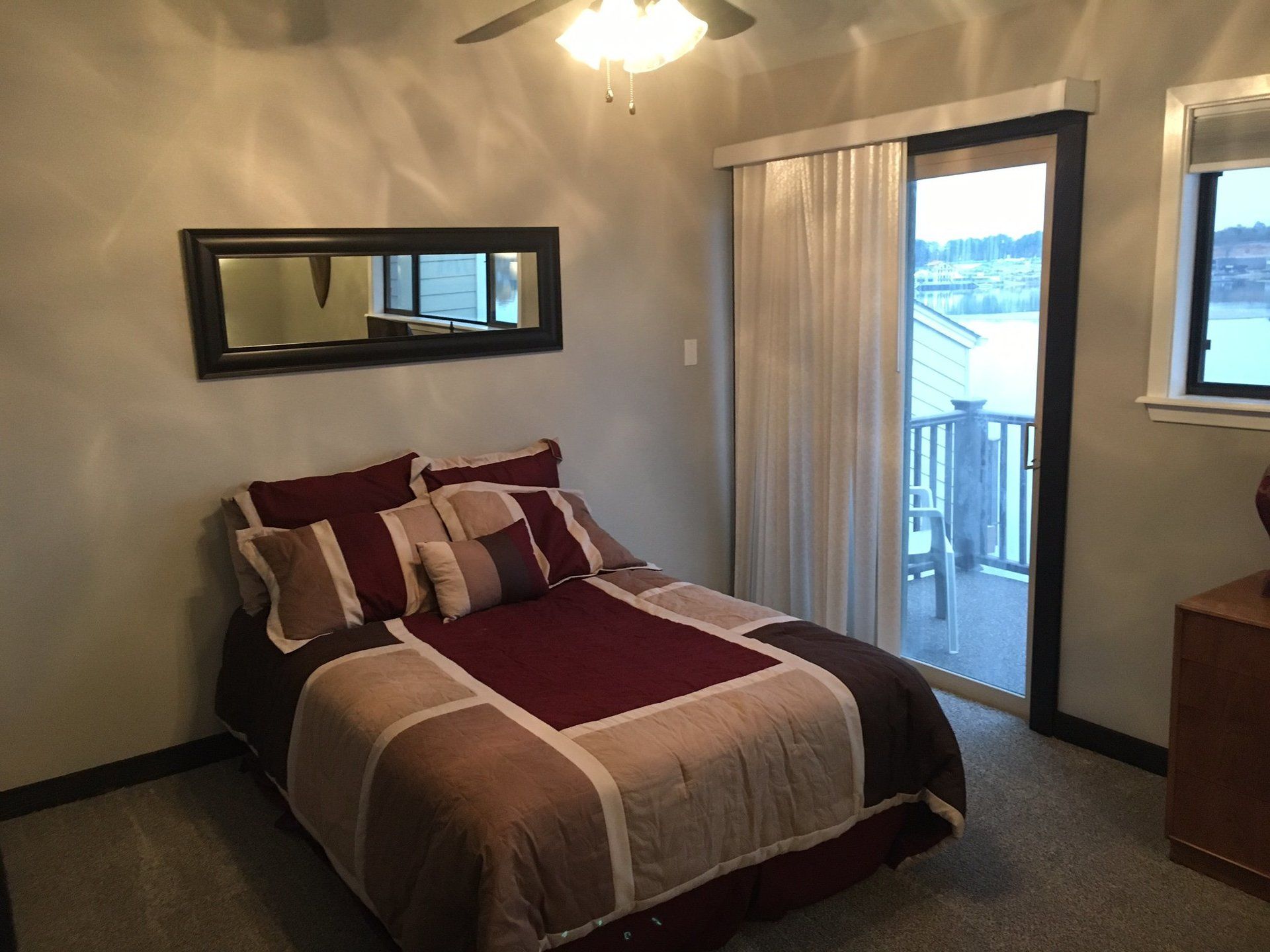 A bedroom with a large bed and a sliding glass door
