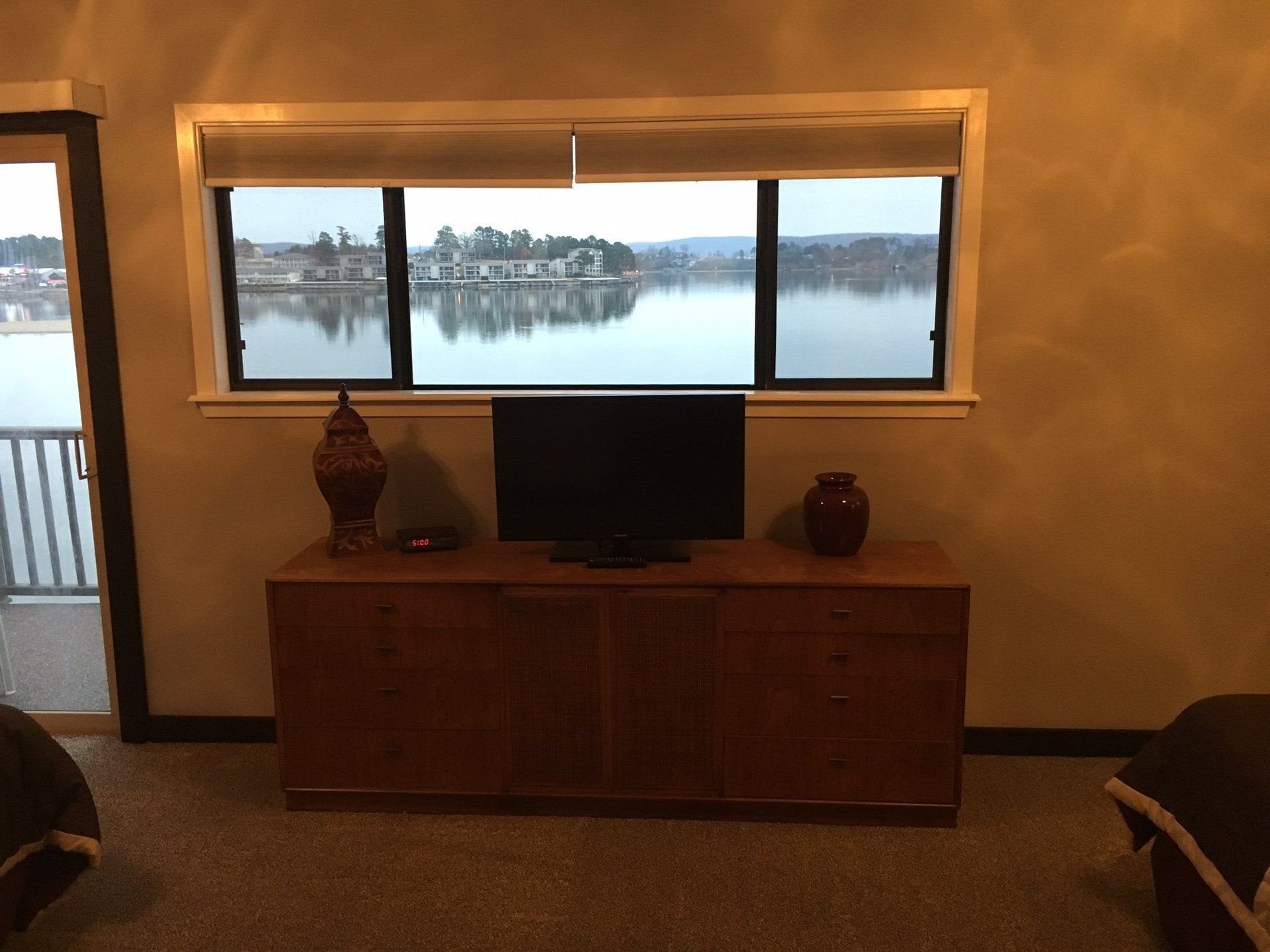 A living room with a large window overlooking a lake.
