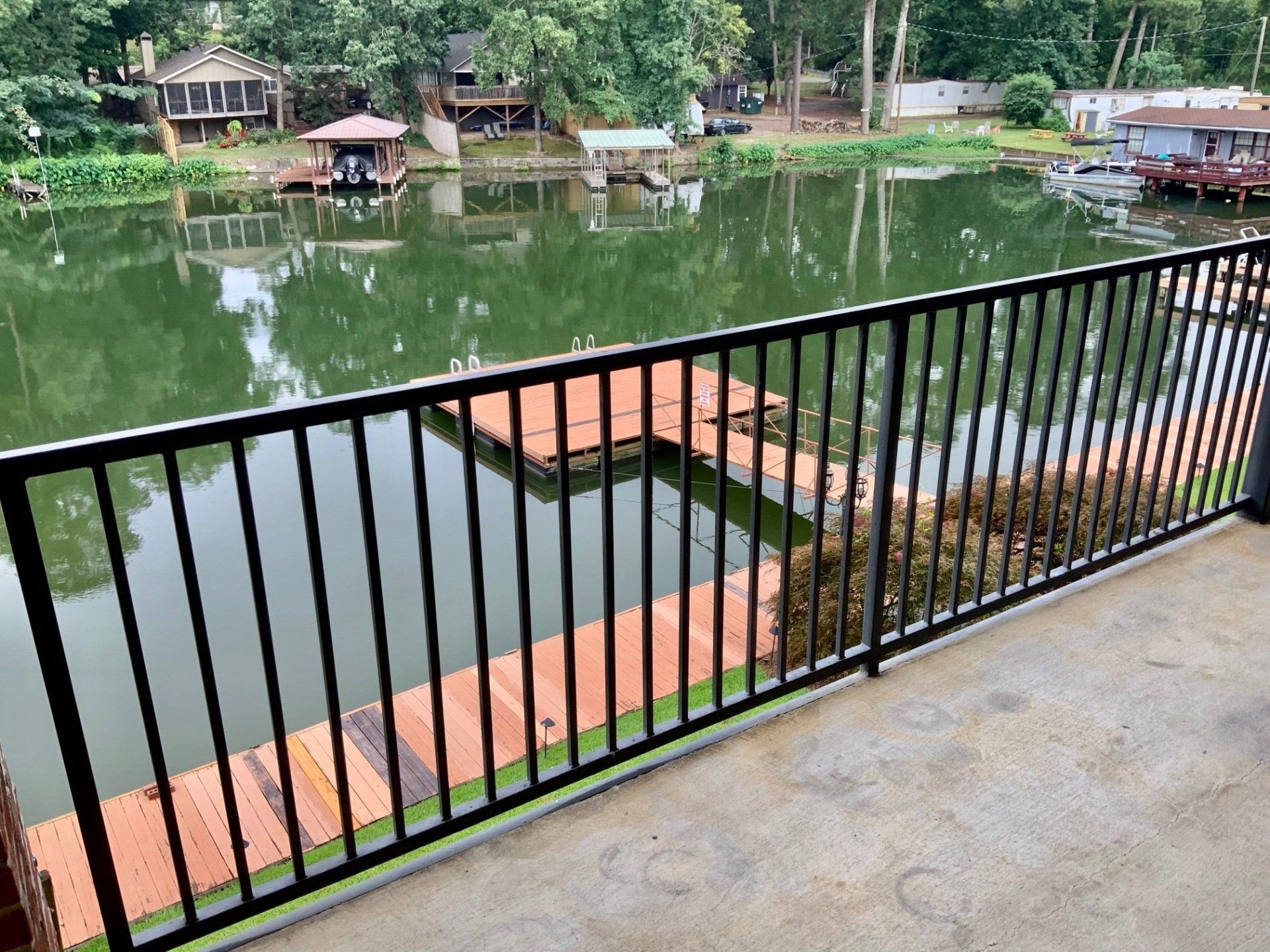 A balcony with a view of a lake and a dock.