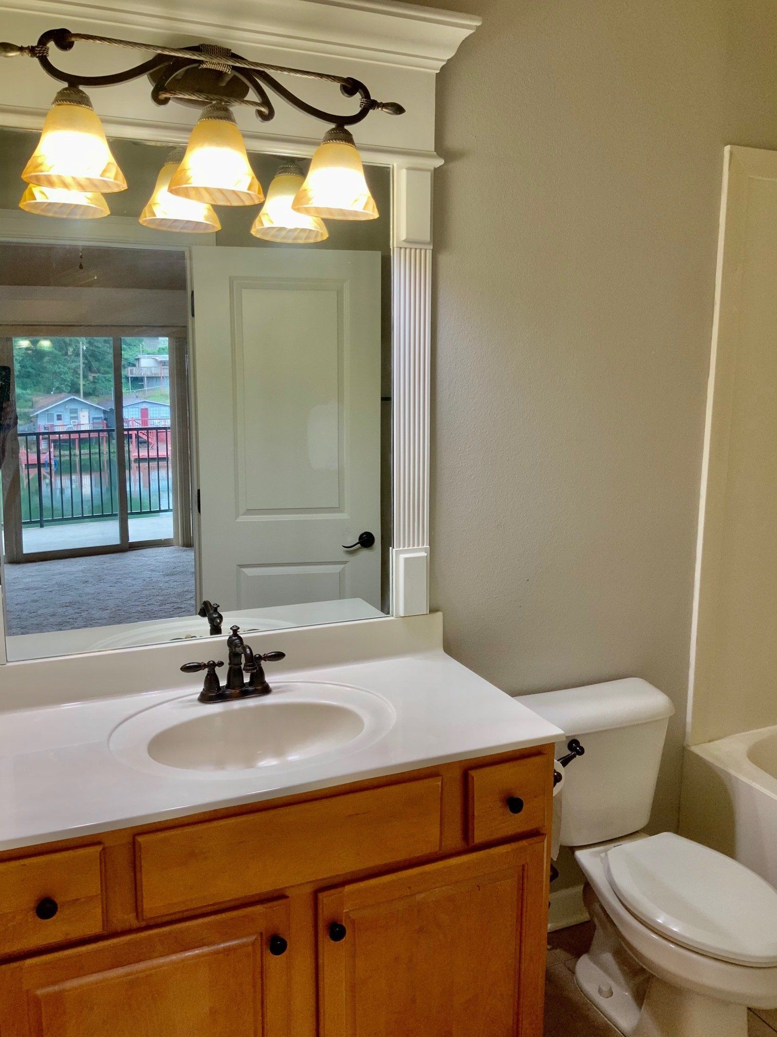 A bathroom with a sink toilet and mirror