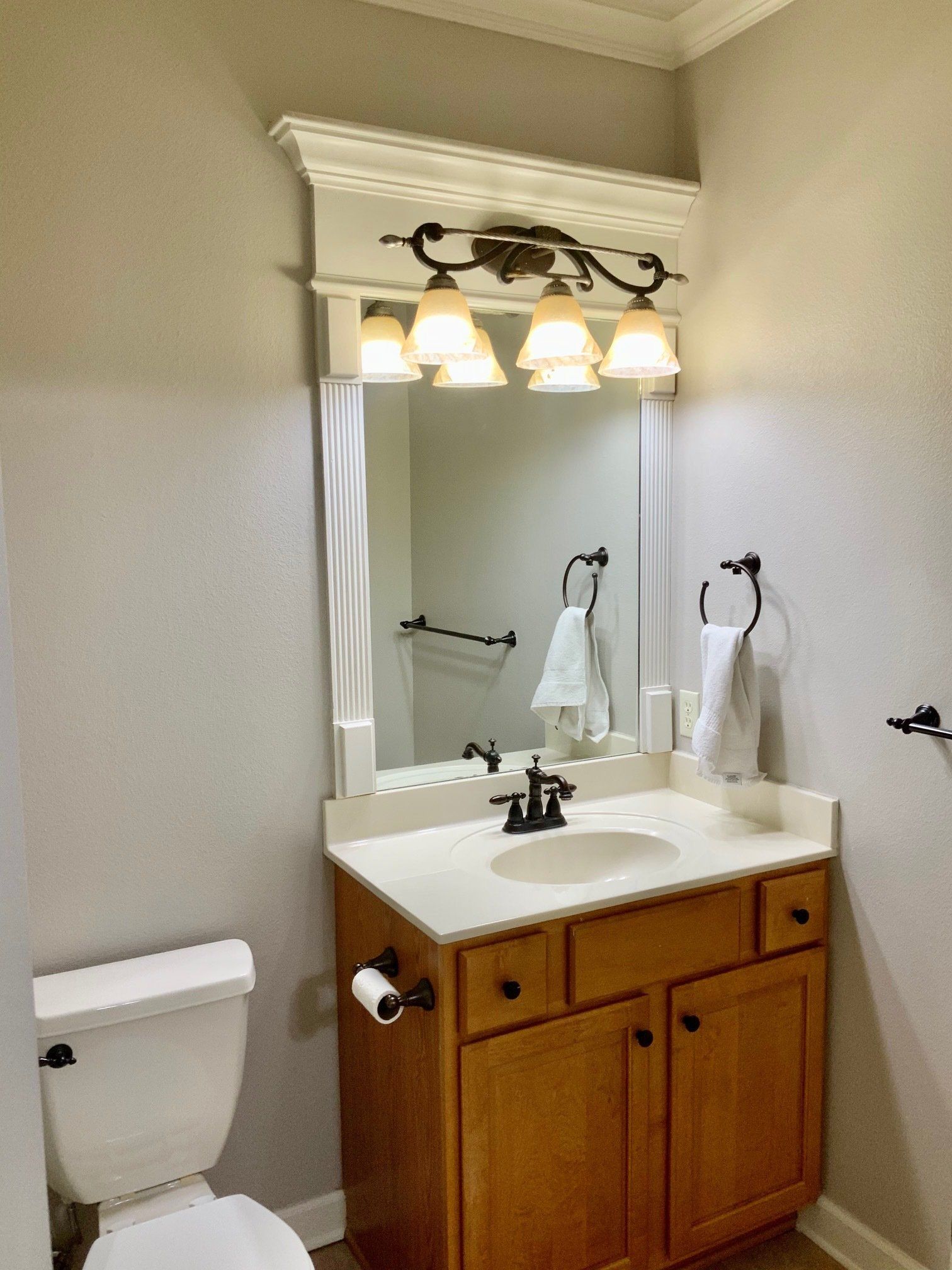 A bathroom with a toilet a sink and a mirror