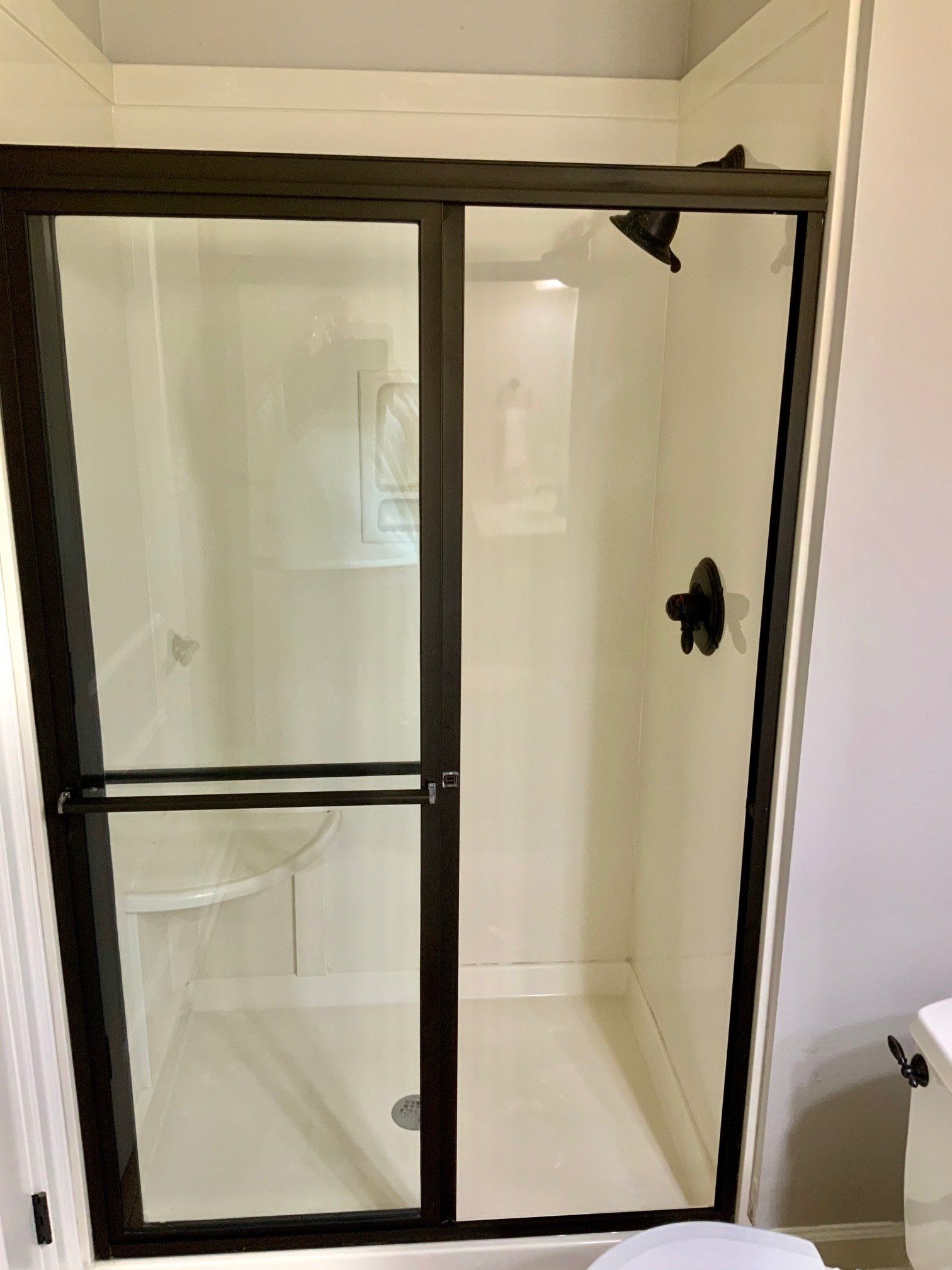 A bathroom with a sliding glass shower door and a toilet.