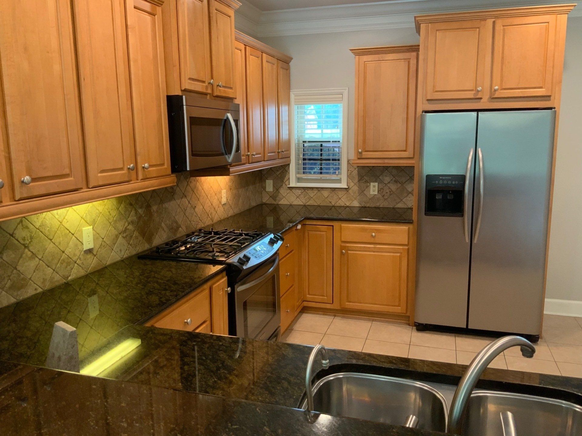 A kitchen with stainless steel appliances and wooden cabinets
