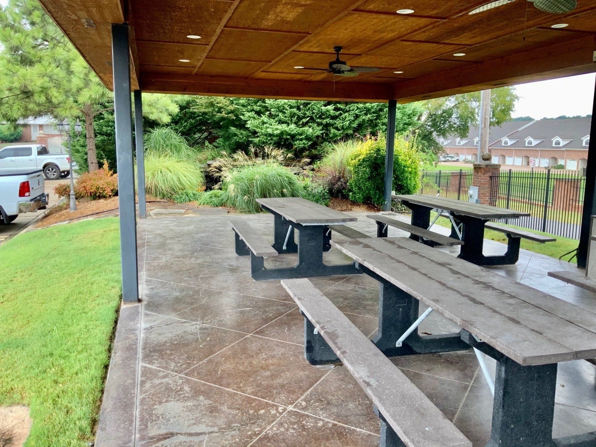 A row of wooden picnic tables under a covered patio.