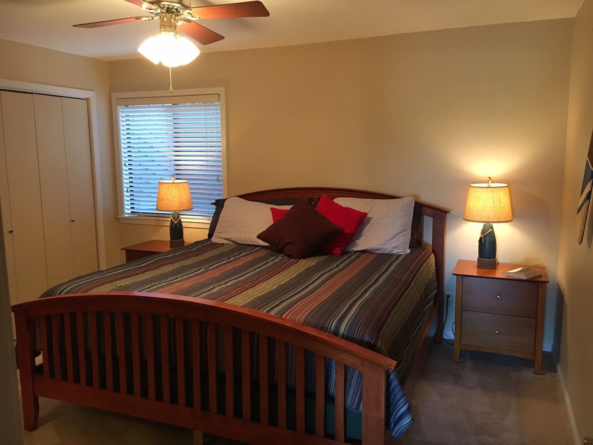 A bedroom with a bed and a ceiling fan