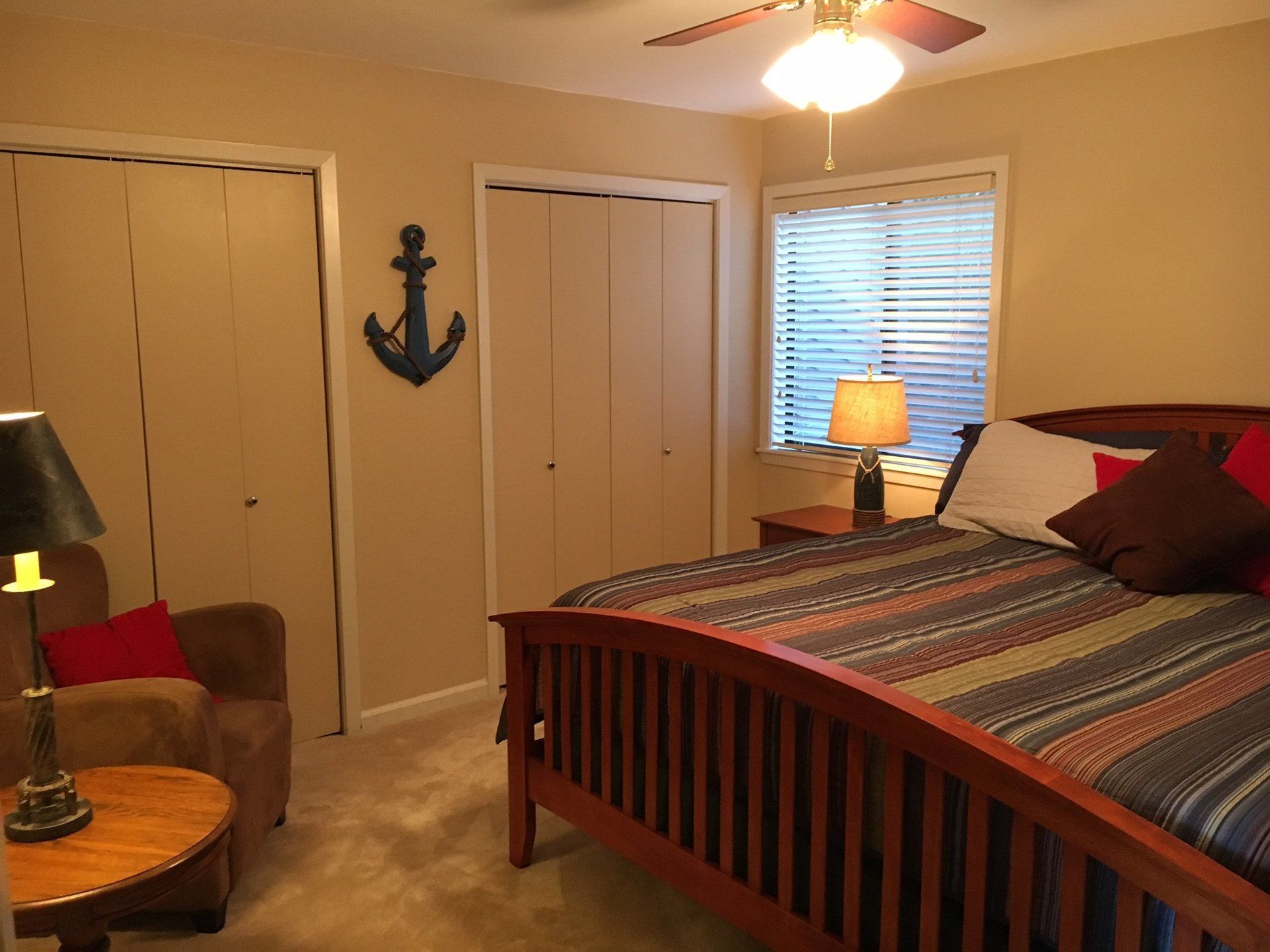 A bedroom with a large bed and a ceiling fan