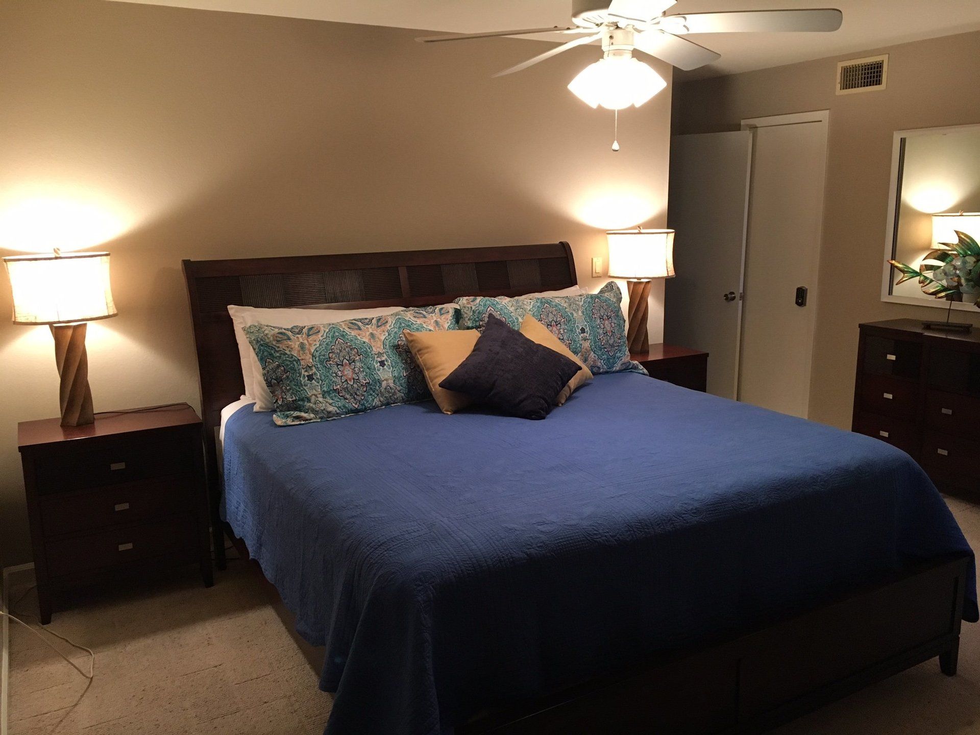 A bedroom with a bed and a ceiling fan