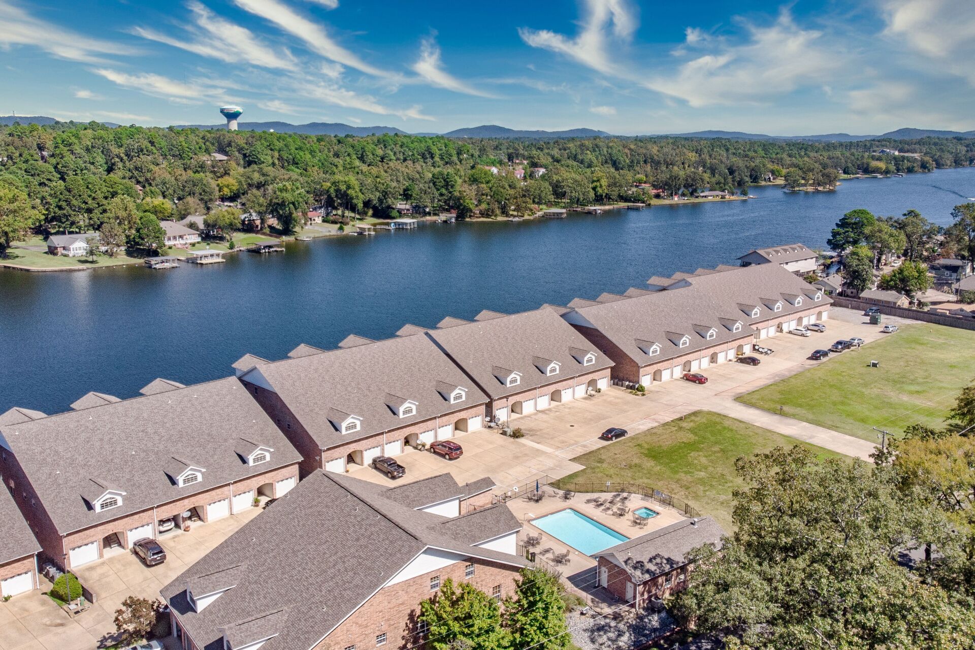 An aerial view of a row of houses next to a lake.
