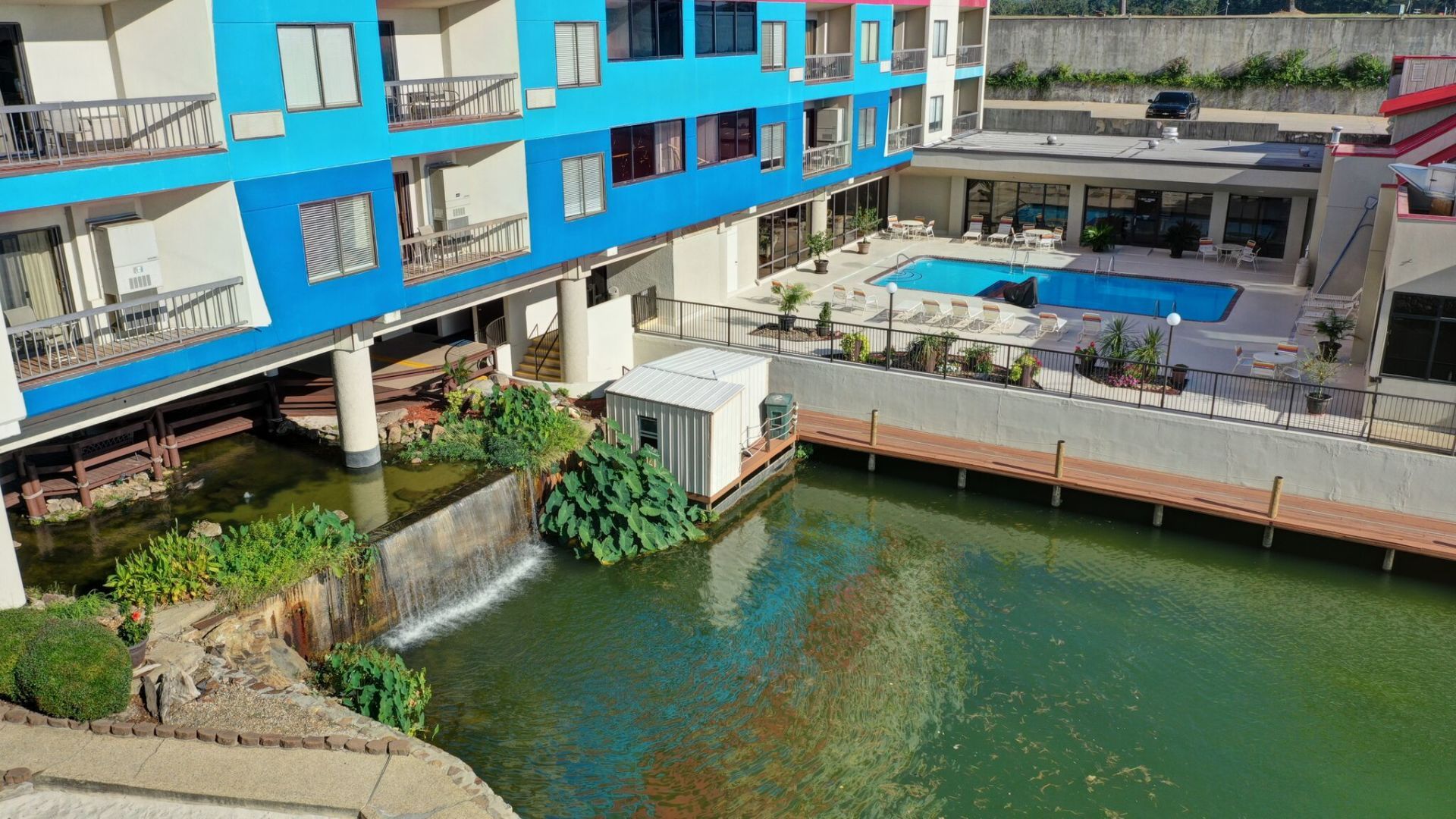An aerial view of a hotel with a swimming pool and a waterfall.