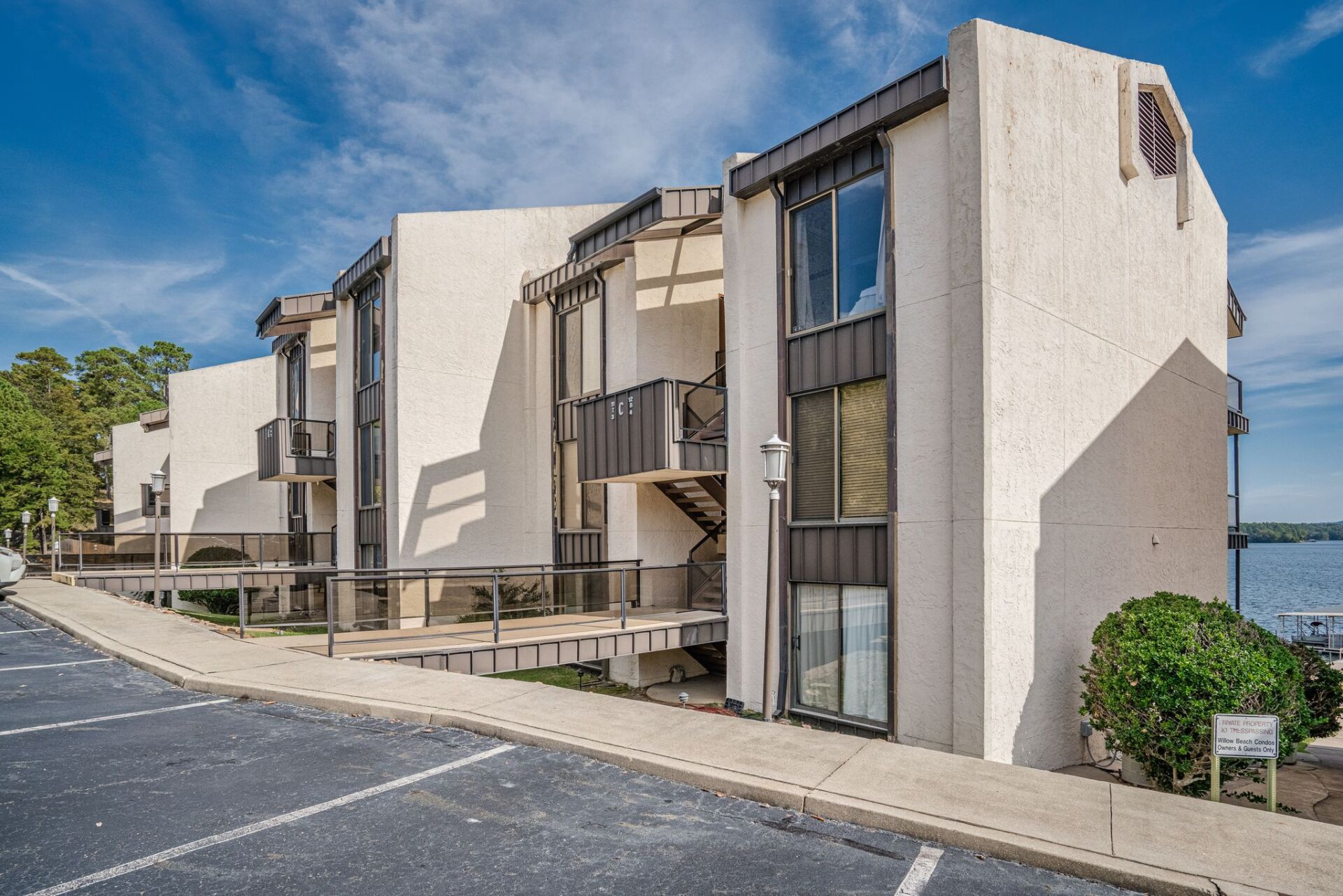 A large white building with a lot of windows is next to a body of water.